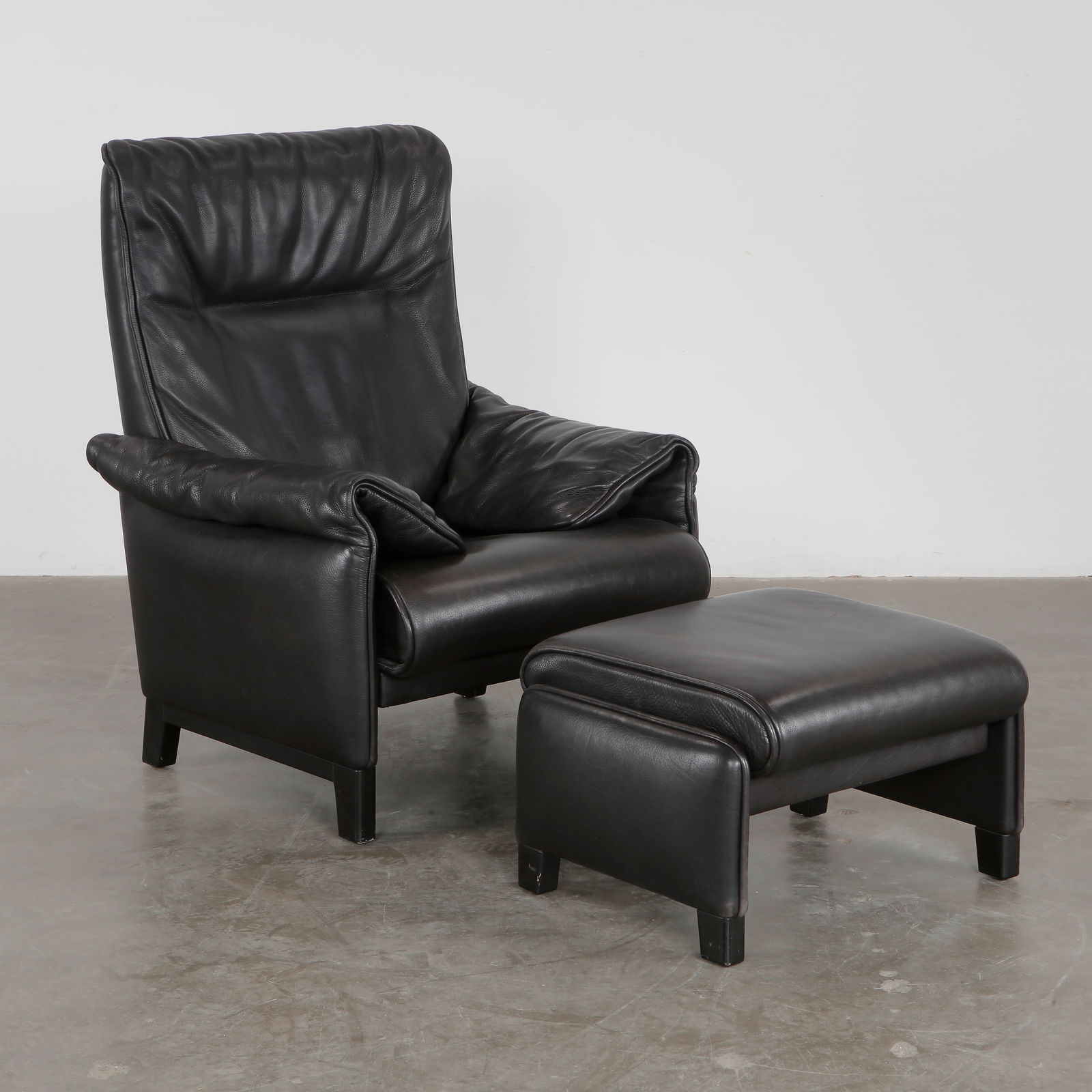 De Sede, Ds 49 Black Leather Armchair with Ottoman, 1970s: Luxurious high-back armchair with Ottoman in supple black leather from the DS-49 series by De Sede. Switzerland, 1970s. Armchair: Height: 32.28 in. Width: 31.50 in. Depth: 33.46 in. Height seat: 15.75