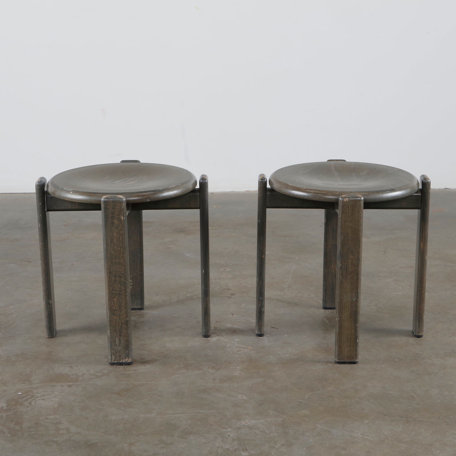 Bruno Rey, Pair of Wood Stools, 1960s: Classic pair of stackable stools in dark-stained wood, designed by Bruno Rey. Switzerland, 1970s. Diameter: 18,3 in. Height: 18.1 in.