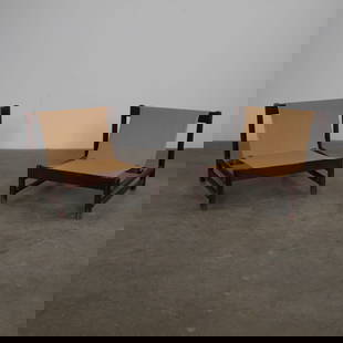 Pair of Lounge Armchairs, Attributed to Jorge Zalszupin, c. 1960s: Evocative of Brazilian mid-century modernism, these low-slung armchairs feature deep frames of dark stained wood paired with neutral fabric slings. A sculptural and inviting duo, recalling the influen