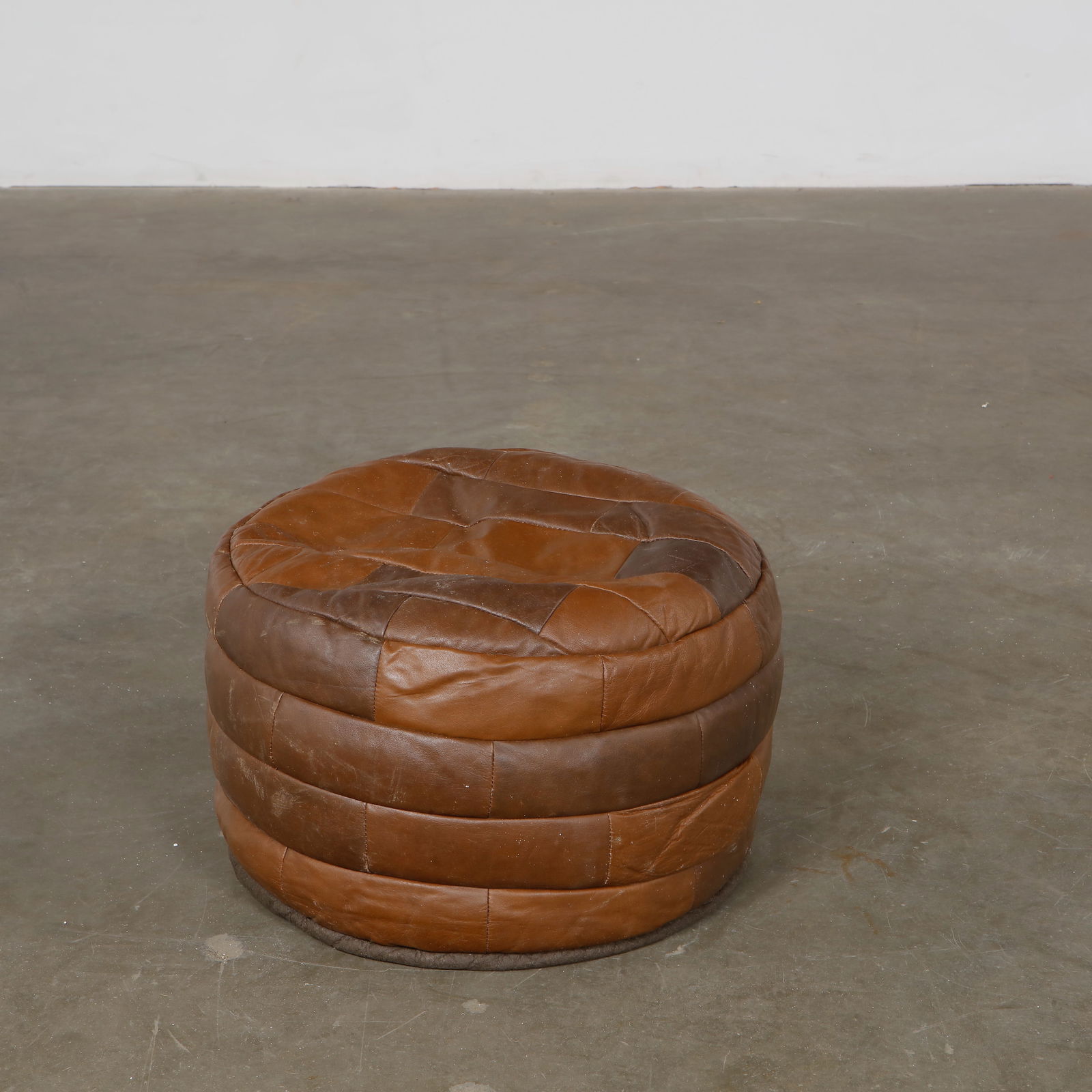 De Sede, Leather 0ttoman, 1960s: Vintage De Sede leather pouf in brown tones. Swiss design, superb patina. Height: 11.5 in. Width: 20 in. Depth: 20 in.