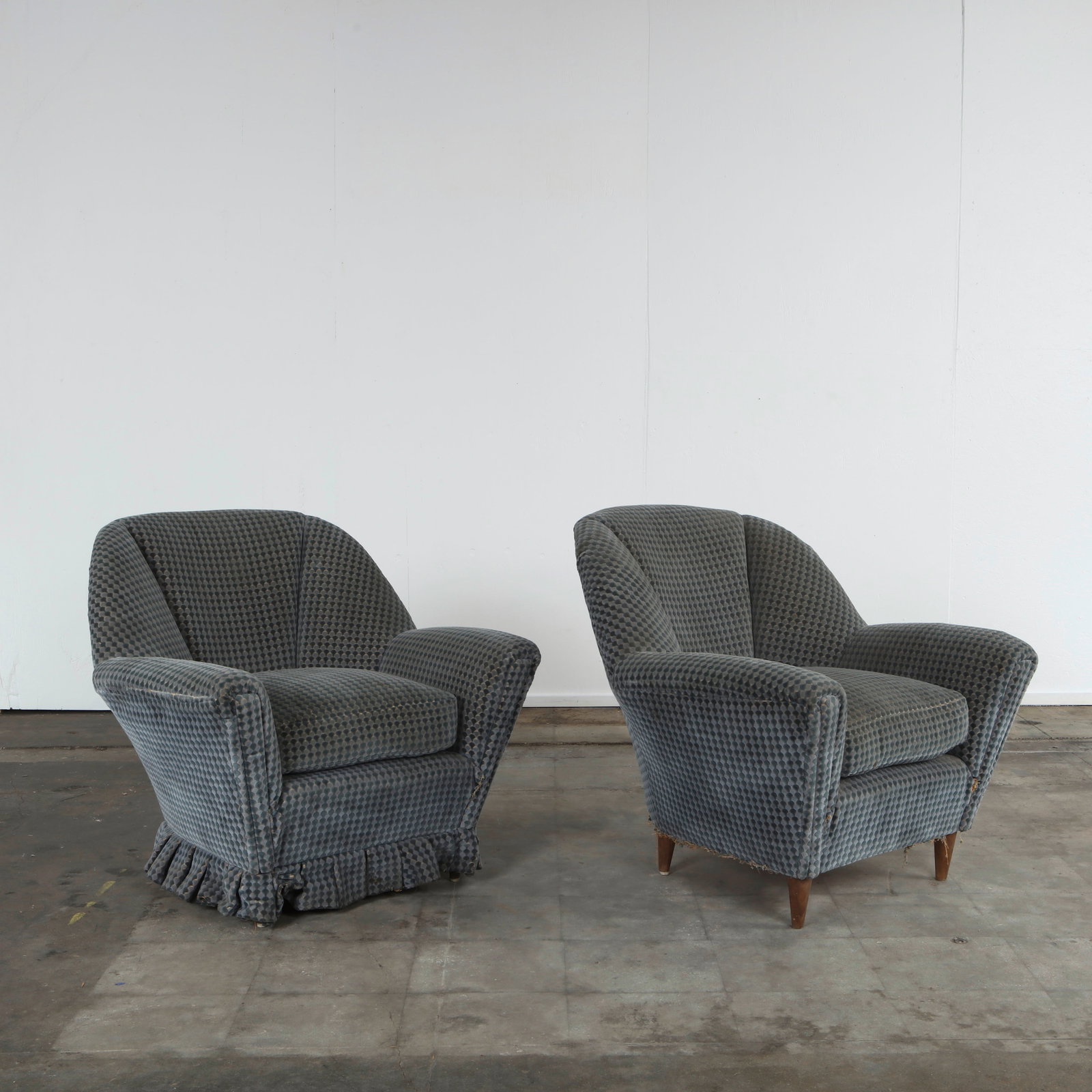 Pair of Mid-Century Blue Green Arnchairs, 1960s: Comfortable lounge chairs in textured blue-green upholstery with gently flared backs and sculptural wooden legs. Height: 32.5 in. Width: 37 in. Depth: 33 in. Seat Depth: 19.5 in.Seat Height: 18 in.