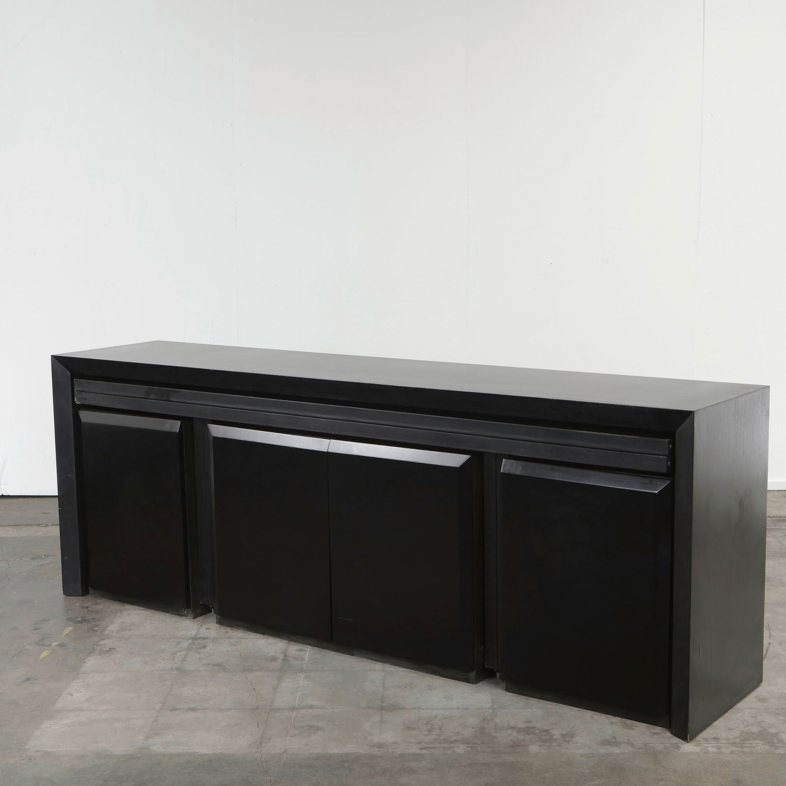 Italian Transformable Sideboard with Extending Console Table, 1970s: A versatile black lacquered sideboard with multiple doors and drawers, opening to reveal generous storage. The piece features an integrated extending console table on casters, allowing it to convert s