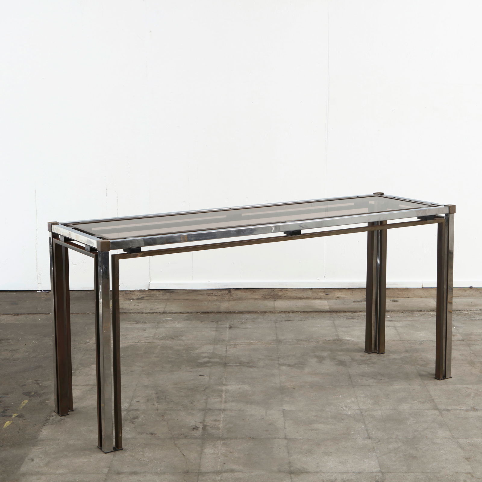 Romeo Rega, Rectangular Glass and Metal Console Table, 1970s: Sleek rectangular console by Romeo Rega, crafted with a smoked glass top supported by a chrome and brass frame. Perfect as a hall, sofa, or display table, it exemplifies the glamorous and architectura