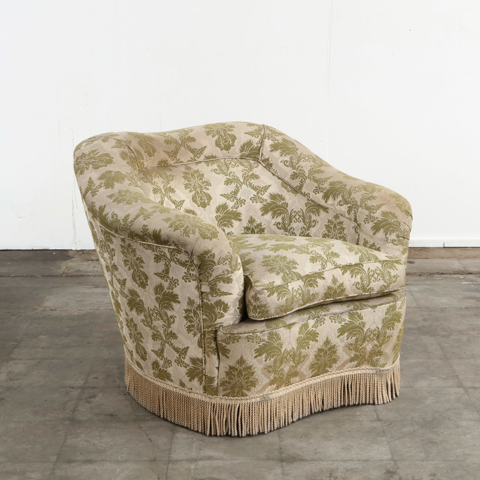 Italian Vintage Armchair in Green Floral Fabric, 1960s: Charming vintage Italian armchair upholstered in green floral patterned fabric. The rounded form, skirted base, and decorative fringe highlight mid-century elegance with a nod to traditional craftsman