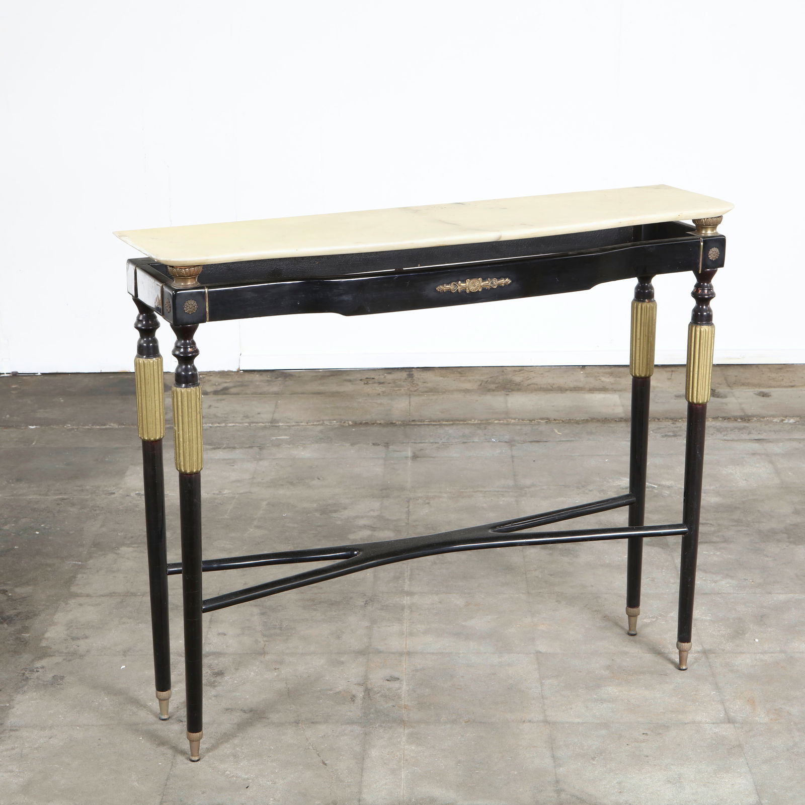 Paola Buffa, Mid-Century Italian Console Table, 1960s: Slender form with ebonized legs, gilt accents, and inset marble top. Subtle neoclassical ornamentation makes it ideal as an entryway. Height: 33 in. Length: 39.5 in. Depth: 11.5 in.
