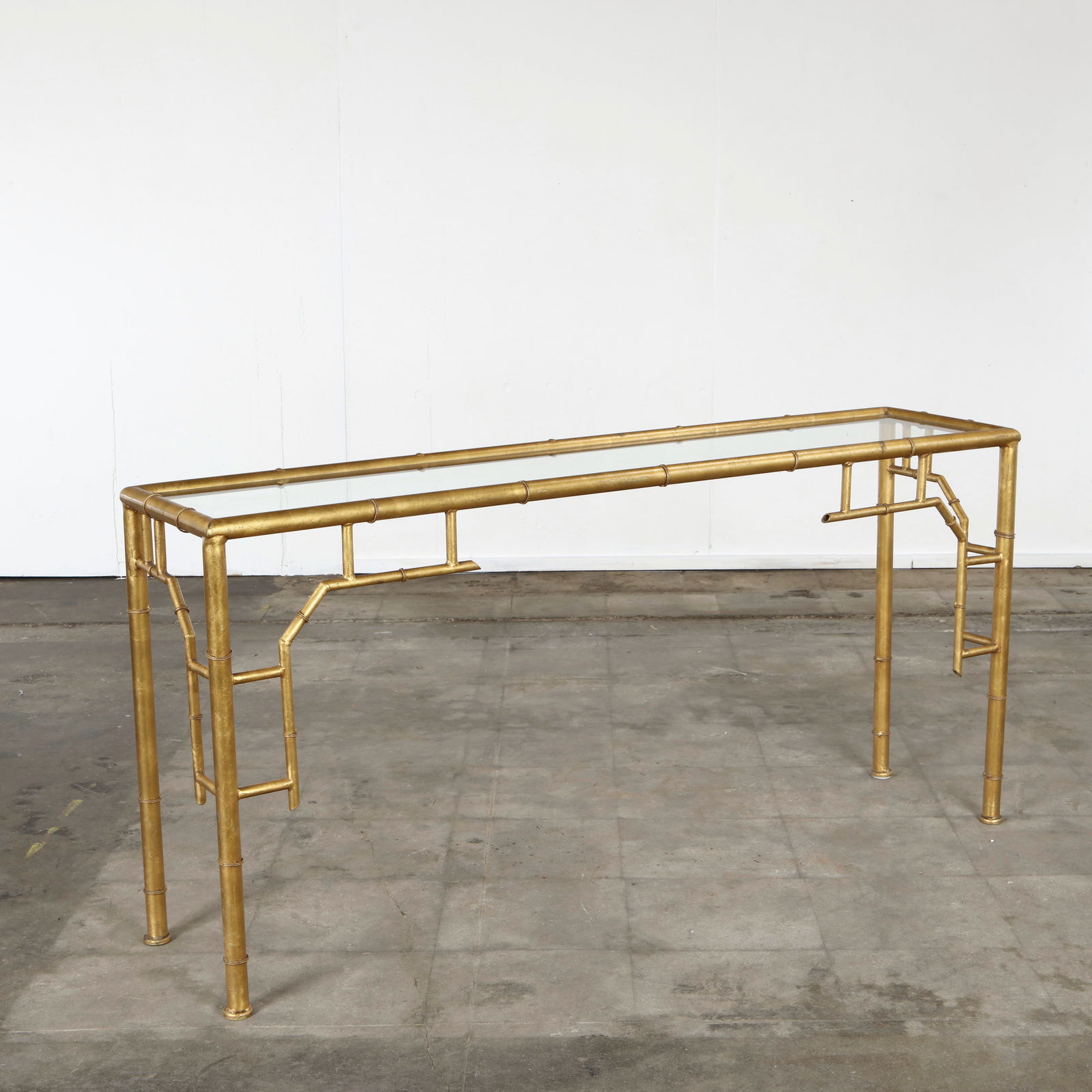 Italian Faux Bamboo Gilt Console Table with Glass Top, 1970s: Frame in gilt faux-bamboo metal with inset glass top. Evokes chinoiserie elegance popular in Italian mid-century interiors. Height: 29 in. Length: 60 in. Depth: 14 in