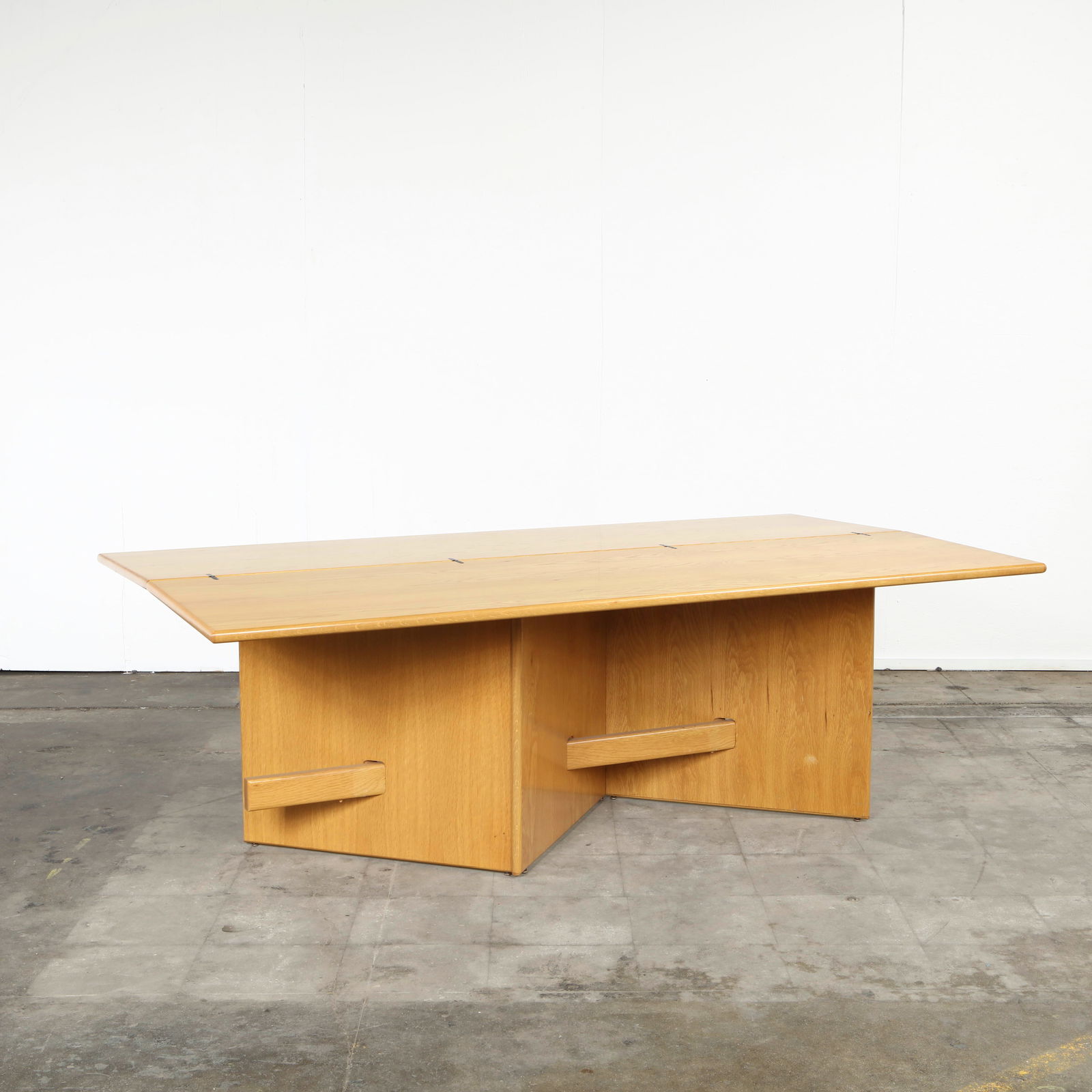 Italian Mid-Century Adjustable Console Table, 1970s: Minimalist oak dining table with geometric pedestal legs, featuring a functional extension top. Elegant and versatile, reflecting postmodern design principles. Height: 29.75 in. Length: 82 in. Width: