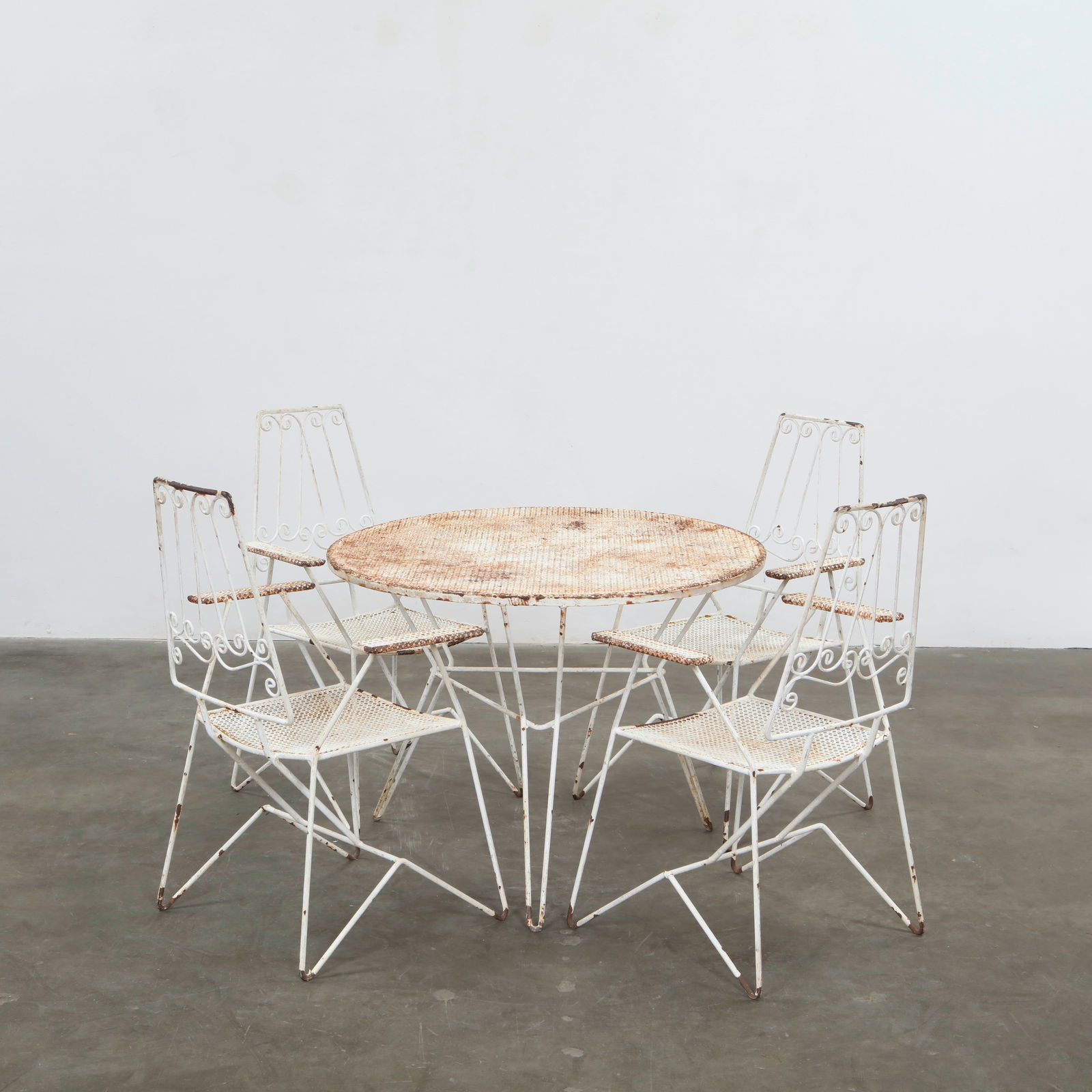 Outdoor Dining Set attributed to Mathieu Mategot, 1950s: A stylish wrought-iron patio set comprising a circular table and four chairs, attributed to Mathieu Mategot. The perforated metalwork and curving lines reflect the artistry of 1950s French design. Hei
