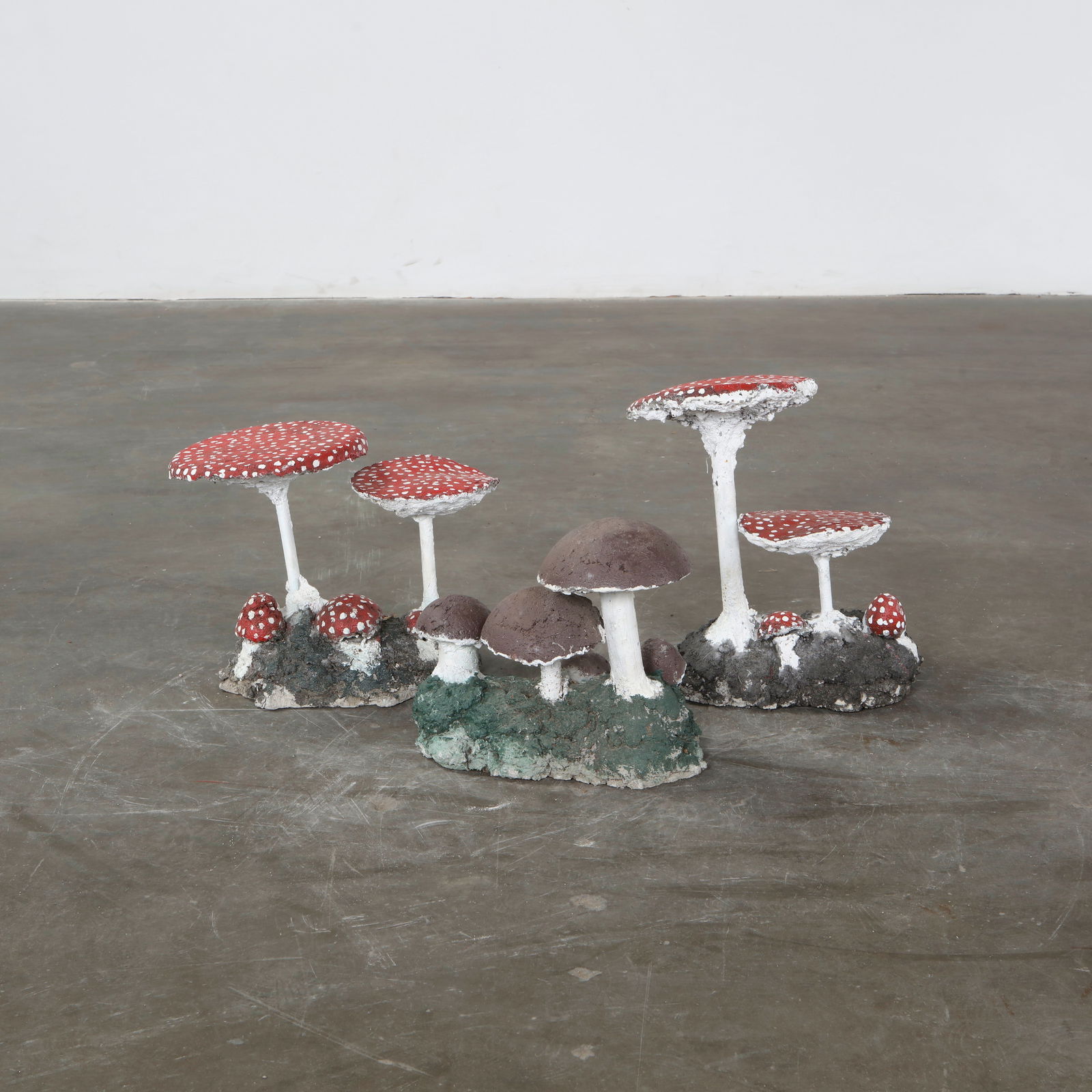 Set of Three Concrete Mushroom Sculptures, 1960s: Whimsical garden sculptures in the form of stylized mushrooms, hand-cast in concrete. Their aged patina and organic shapes bring a playful yet natural touch to outdoor settings. Red : Height: 14 in. W
