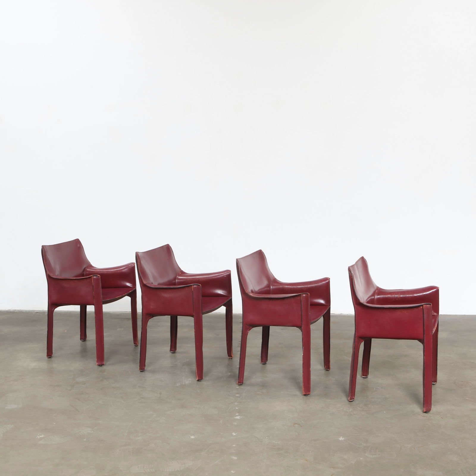 Mario Bellini for Cassina, Set of Four Cab Red Leather Dining Chairs, Italy, 1980s: Upholstered in deep red saddle leather, these architectural chairs display Bellini mastery of form and proportion. The seamless construction and supple patina illustrate Italian craftsmanship at its m