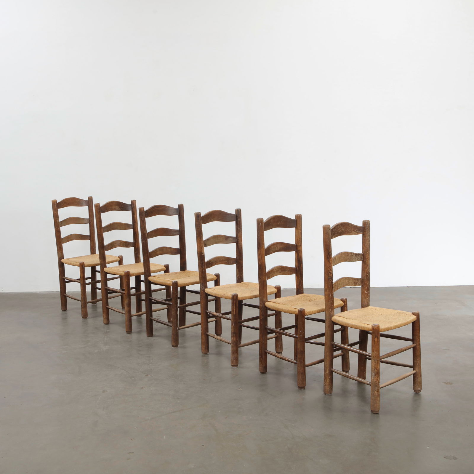 Set of Six Wood and Rope Chairs in the Style of Charlotte Perriand, France, 1950s: Each chair features a woven rope seat and solid wood frame, combining artisanal weaving with a modern rustic spirit. A design language that echoes Perriand work for Les Arcs. Height: 37.5 in. Width: 1