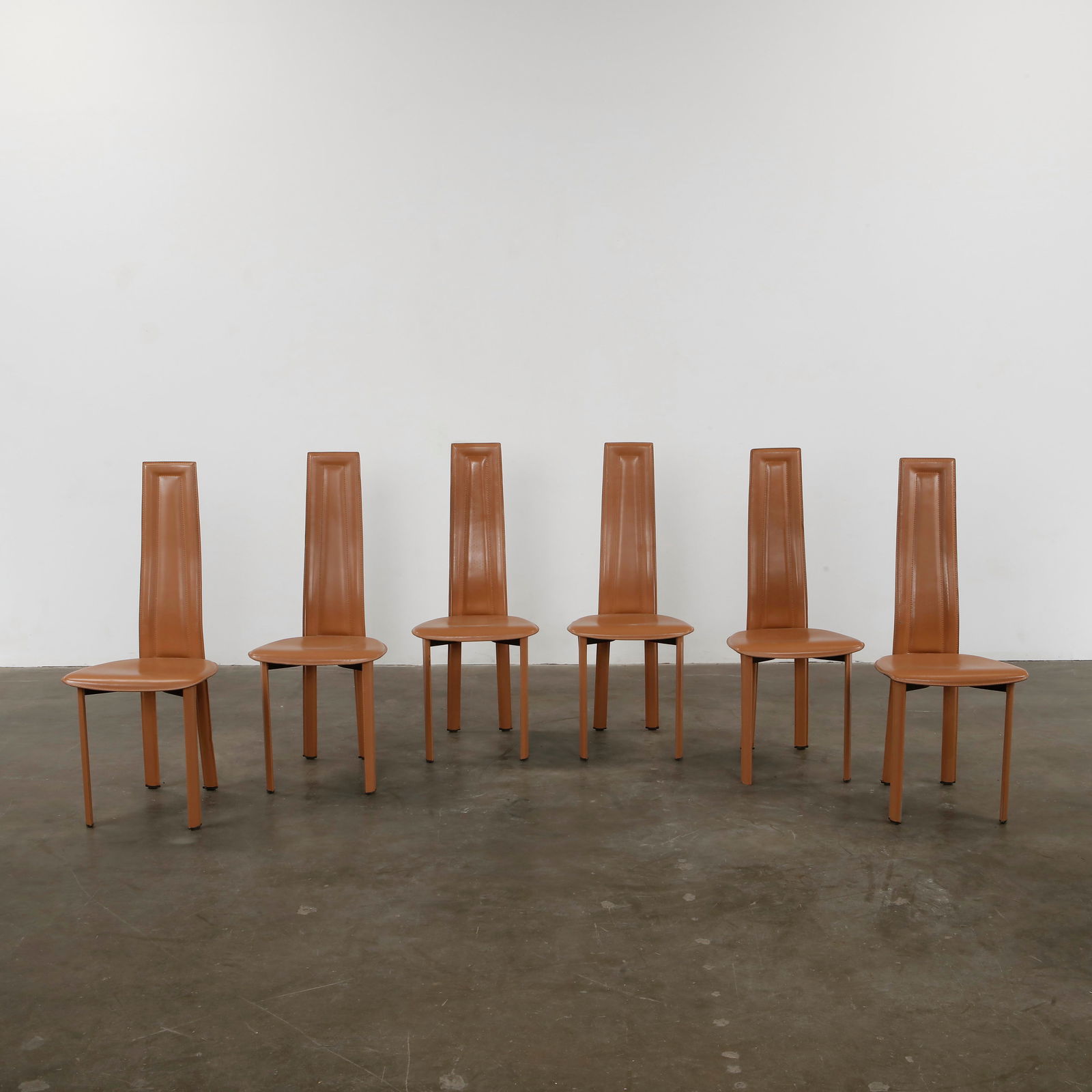 Roche Bobois, Set Of Six High Back Dining Room Chairs, 1980s: Sleek and modern set of six high-back dining chairs by Roche Bobois, fully upholstered in cognac leather. Elegant and comfortable. Chairs: Height: 43 in. Width: 17.5 in. Depth: 16.1 in. Seat Height: 1