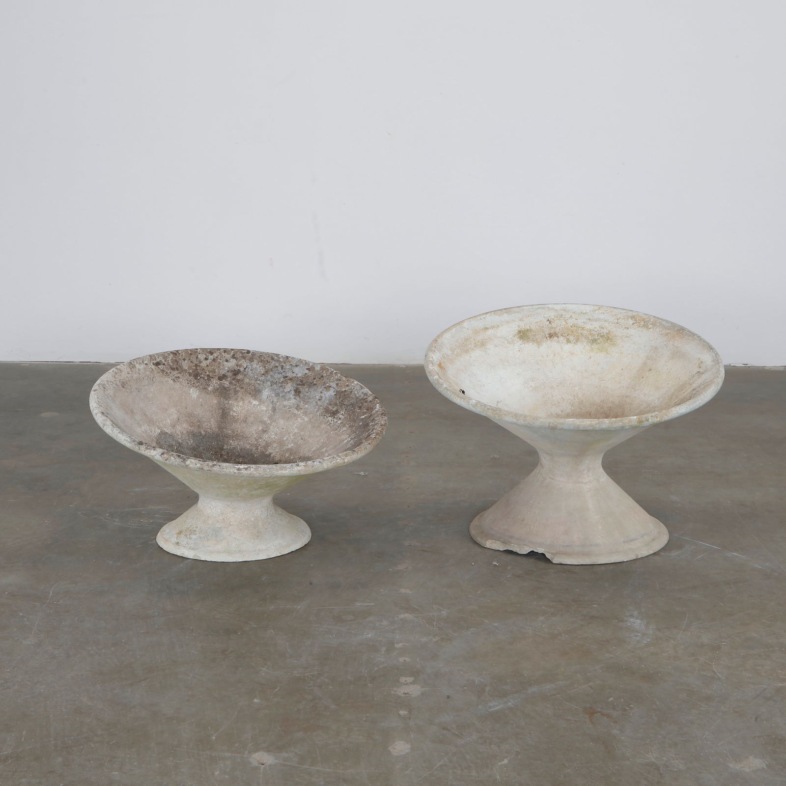 Willy Guhl, Pair of Short Off-Kilter Planters, 1960s: A pair of rare asymmetrical planters by Willy Guhl, featuring a bold modernist design. TOP Diameter: 25 in. BASE Diameter: 13 in. Height: 14.5 in.