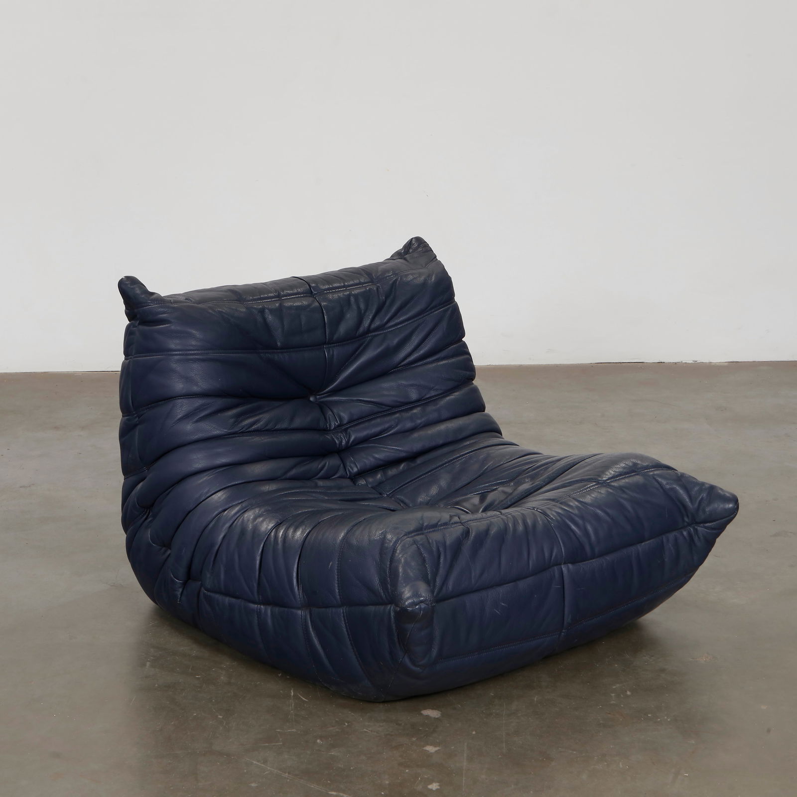 Michel Ducaroy for Ligne Roset, Navy Blue Single Seat Togo, 1980s: Single-seat Togo armless lounge chair in navy blue leather by Michel Ducaroy for Ligne Roset. A standalone statement or modular component, it embodies the relaxed yet avant-garde spirit of postwar Fre