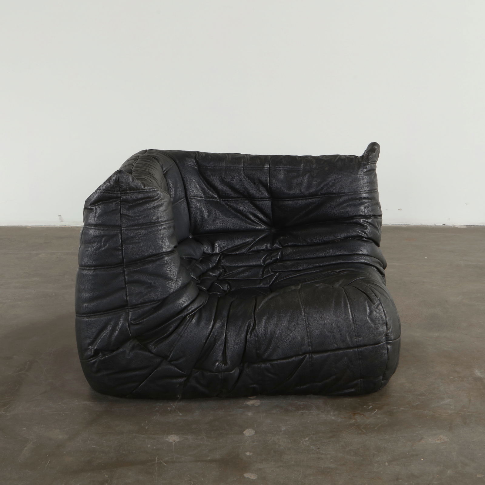 Michel Ducaroy for Ligne Roset, Black Corner Togo Sofa, 1990s: Upholstered in supple black leather, this Togo module showcases Ducaroy's celebrated study of relaxed ergonomics. Its pleated surface and low voluminous form express an iconic vision of late twentieth