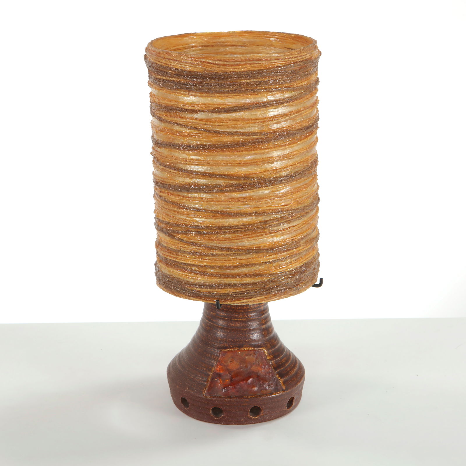 Accolay, Ceramic Table Lamp, 1960s: Formed in textured ceramic with amber-tinted resin inserts, this lamp radiates a warm atmospheric glow characteristic of Accolay workshops. The interplay between rough ceramic and luminous resin creat