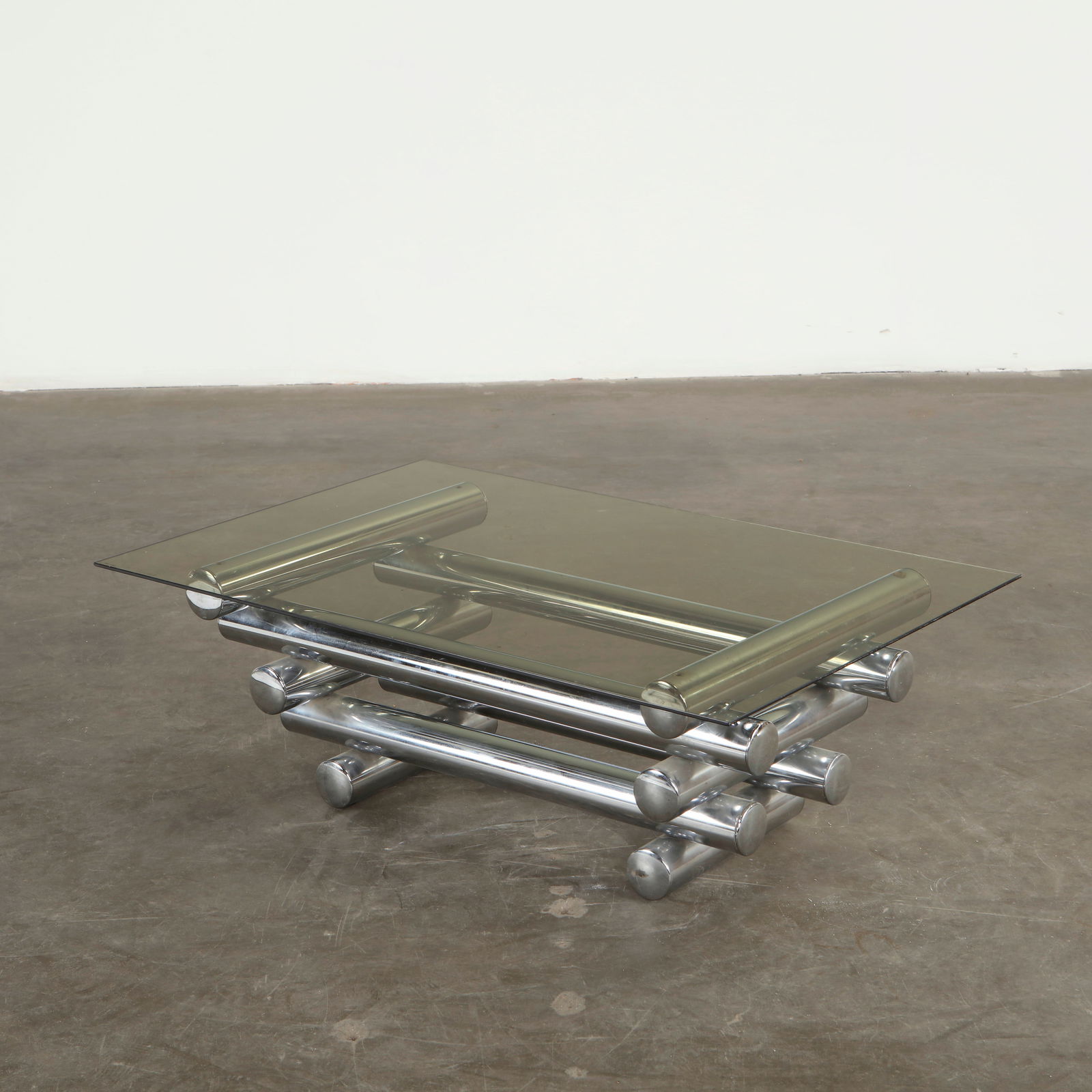 Glass Coffee Table attributed to Paul Mayen, 1960s: Featuring a smoked glass top resting on tubular chromed supports, this table exemplifies the clean industrial vocabulary associated with Mayen. The transparent plane and mirrored structure offer a har