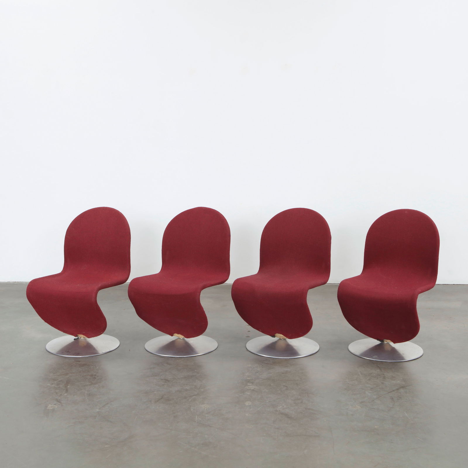 Verner Panton, Set of Four System 1-2-3 Chairs, 1970s: Set of four swivel lounge chairs upholstered in deep red fabric over polished metal bases. Designed for Fritz Hansen, these iconic forms express Panton futuristic sensibilities and sculptural mastery.