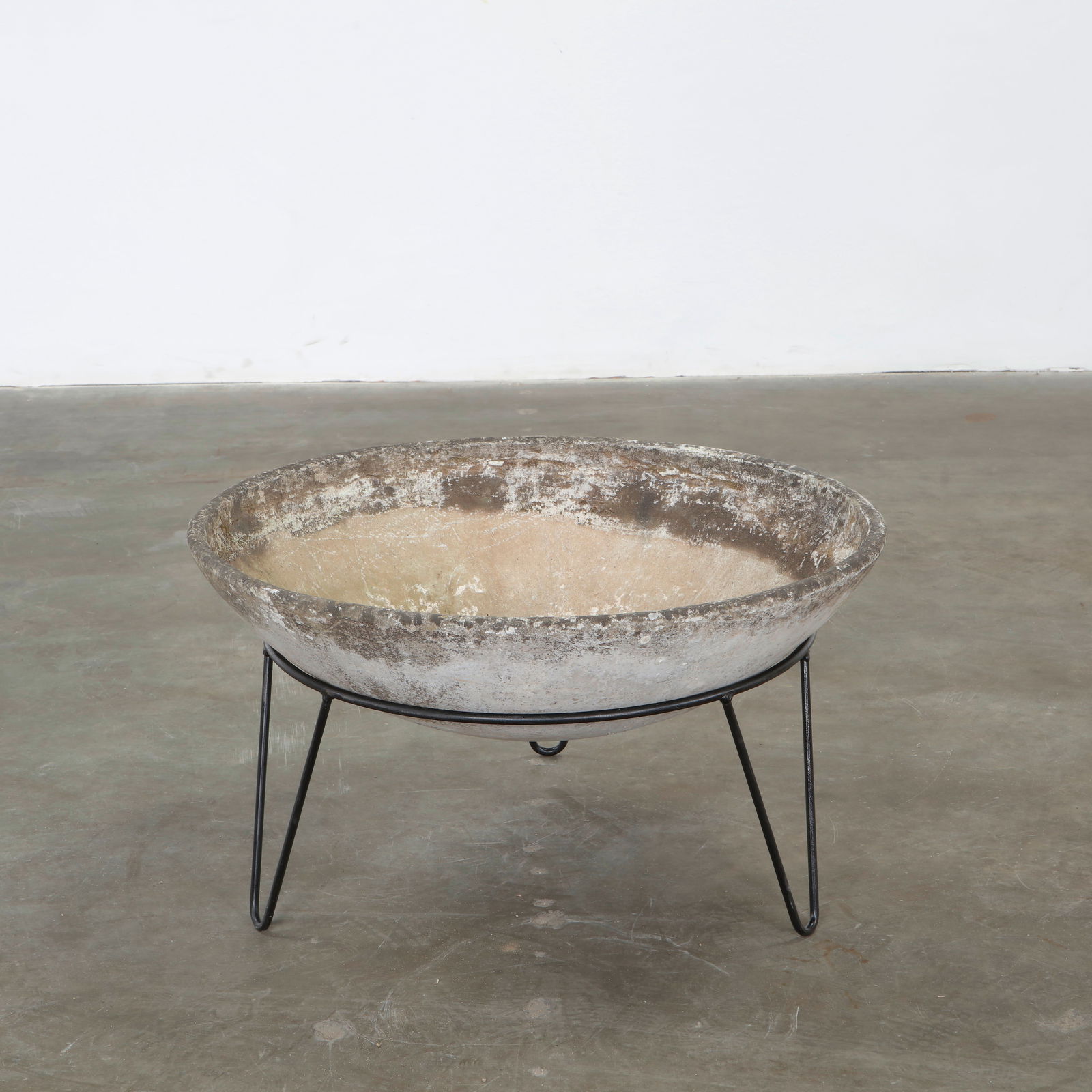 Willy Guhl, Bowl Planter on Stand, 1960s: This planter presents a shallow circular bowl in concrete resting on slender black metal legs. Designed by Willy Guhl, it exemplifies his sculptural approach to functional outdoor forms. The weathered