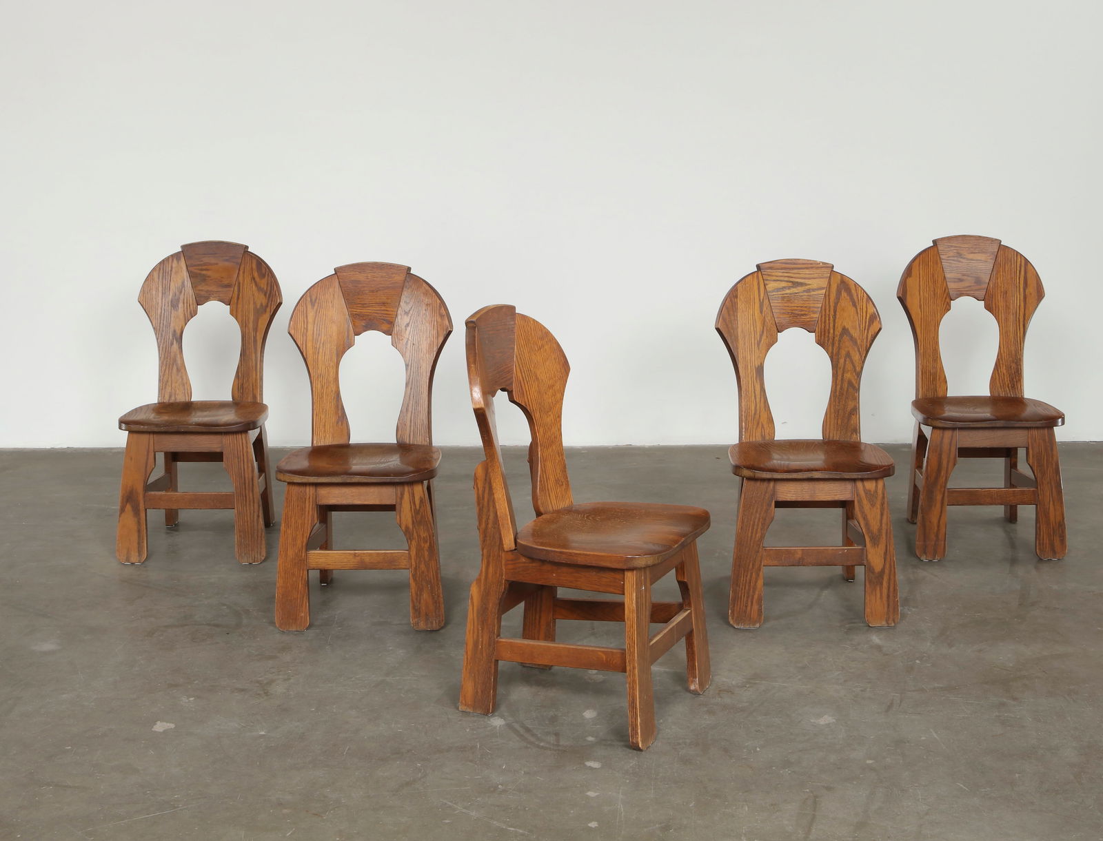 Set of Six Oak Brutalist Dining Chairs, 1970s: Carved in solid oak with expressive sculpted backs, these chairs capture the bold materiality of French Brutalist design. The pronounced grain, hand shaped contours, and sturdy frames convey a strong