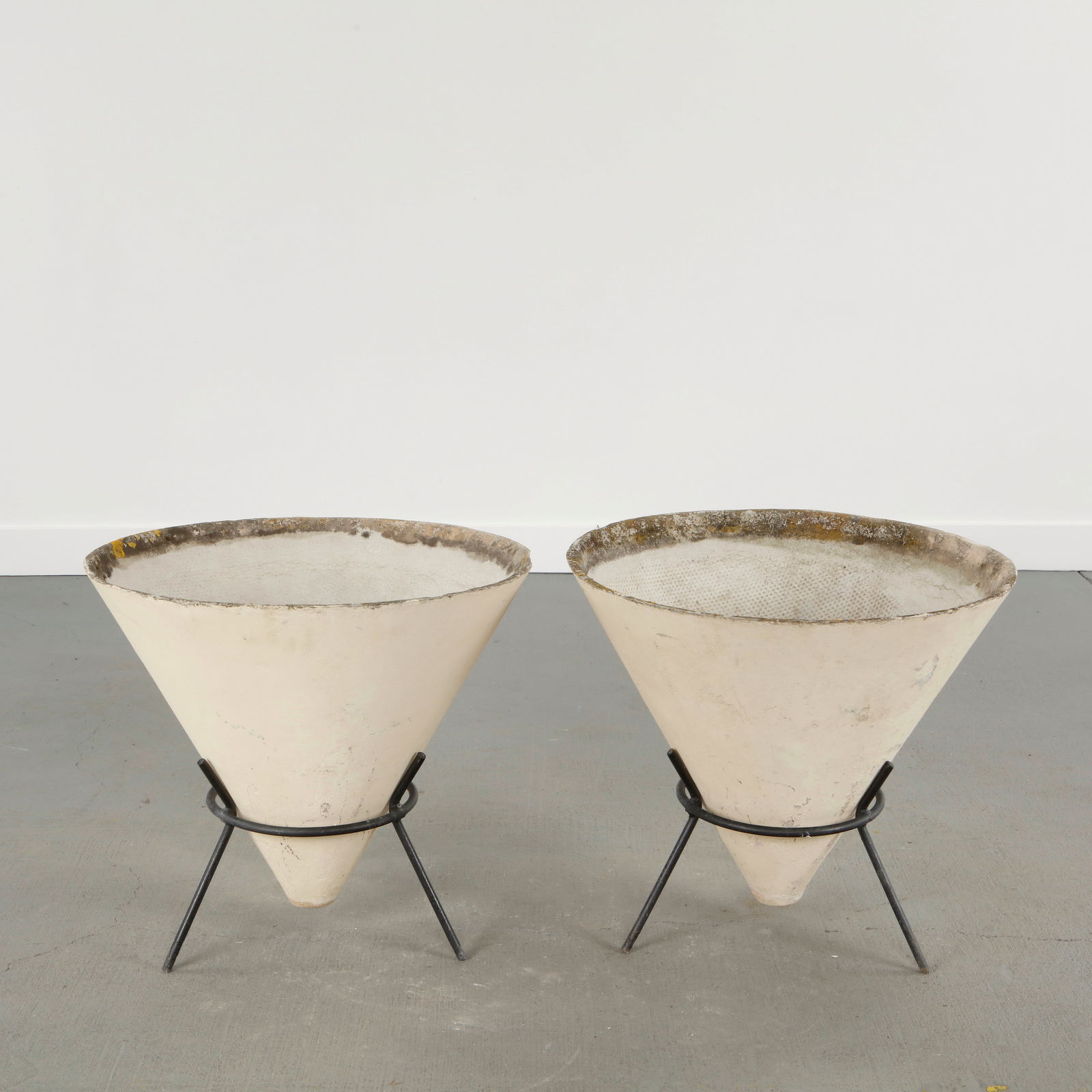 Willy Guhl, Pair of Conical Planters on Stands, 1960s: Iconic Willy Guhl silhouettes in compact form, these conical planters rest atop minimalistic metal stands, weathered yet timeless. Height: 21 in. Diameter: 23.5 in.
