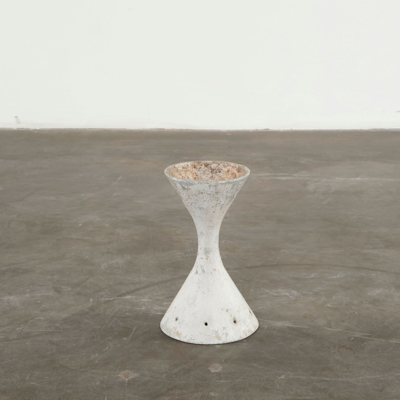 Willy Guhl, Miniature Diabolo Planter, 1960s: A very small hand-cast cement planter, showcasing the iconic hourglass silhouette in an unusually petite scale. Its weathered surface and layered patina highlight decades of outdoor aging, giving the