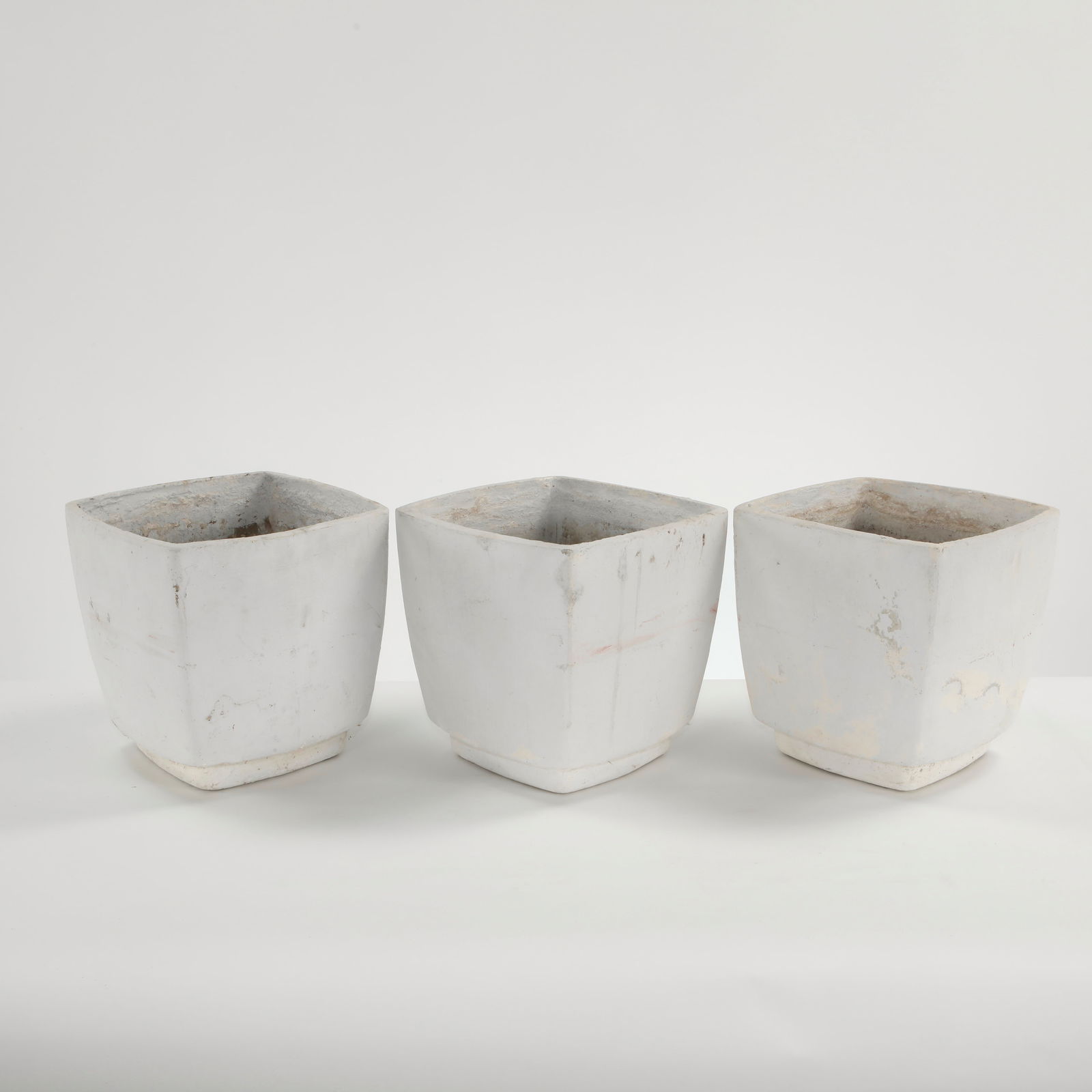 Willy Guhl, Set of Three White Concrete Planters, 1960s: A refined set of three molded concrete planters executed in white cement, featuring crisp geometric profiles and subtly tapered forms. A rare modular ensemble exemplifying Guhl's mastery of