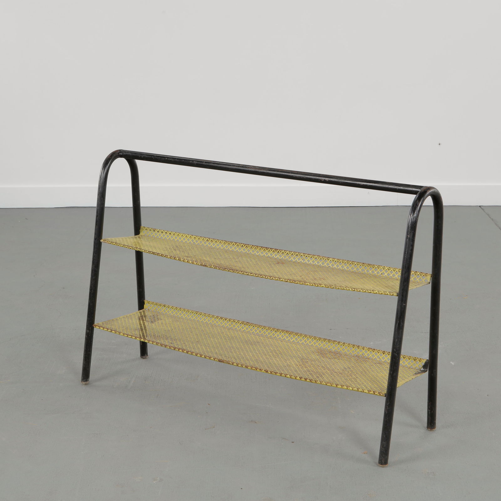 Mathieu Mategot, Perforated Metal Shelf, 1950s: Executed in folded perforated steel featuring rhythmic geometry associated with French modernist metalwork reflecting a postwar dialogue between industrial technique and refined domestic utility.
