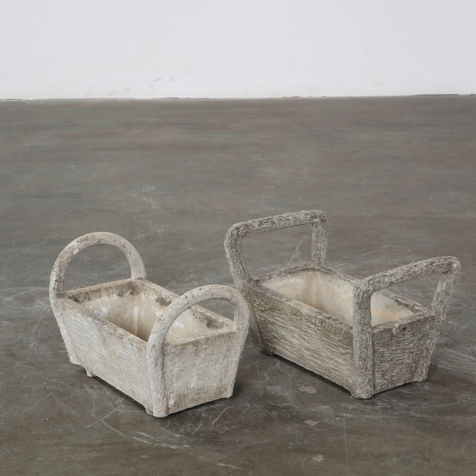 Pair of Faux Bois Basket Planters, France, 1950s: Formed in cast concrete with arched handles and woven texture, these planters echo the domestic intimacy of basketry while embodying durable outdoor craftsmanship. A poetic dialogue between utility