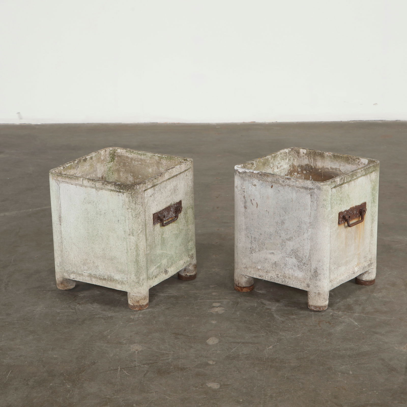 Willy Guhl, Pair of Square Planters with Metal Handles, 1960s: Crafted by Willy Guhl in cast concrete, this pair showcases the designer distinctive utilitarian aesthetic, combining durability with refined proportions. The surfaces display an evocative patina of