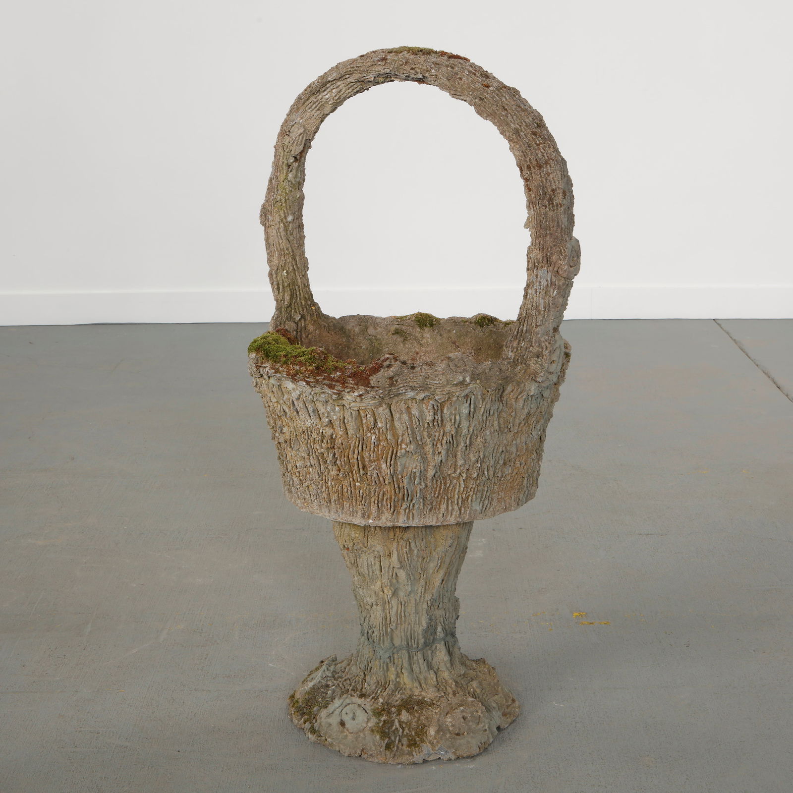 Monumental Concrete Basket Planter, 1960s: Large concrete planter executed in faux bois, featuring a basket form with integrated handle.An expressive example of postwar garden sculpture combining rustic ornament and scale. Height: 42.5 in.