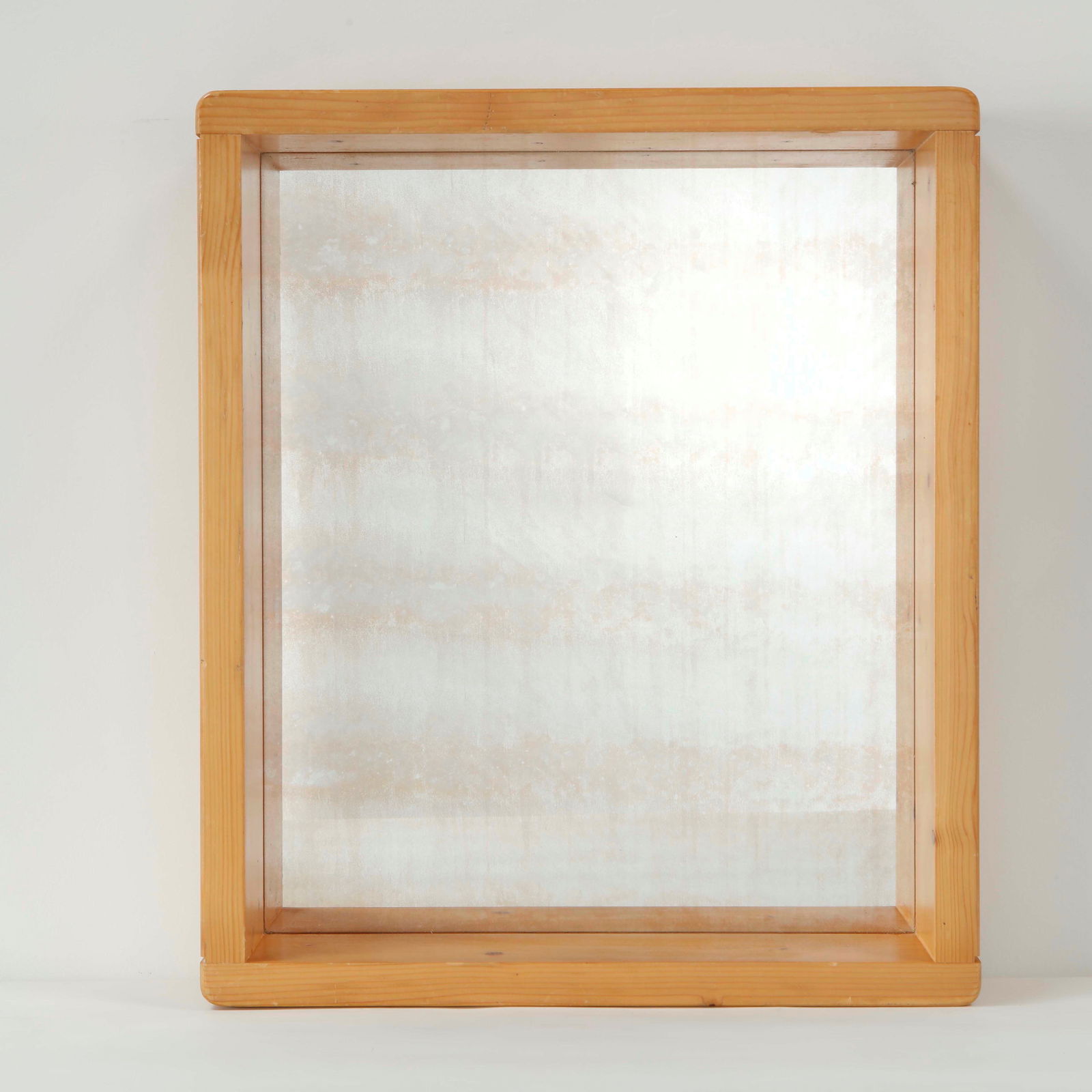 Maison Regain, Pine Mirror, 1960s: Single mirror with antique glass executed in solid pine with clean proportions and expressive grain. A refined decorative element rooted in French modern rustic design. Height: 24 in. Length: 20 in.
