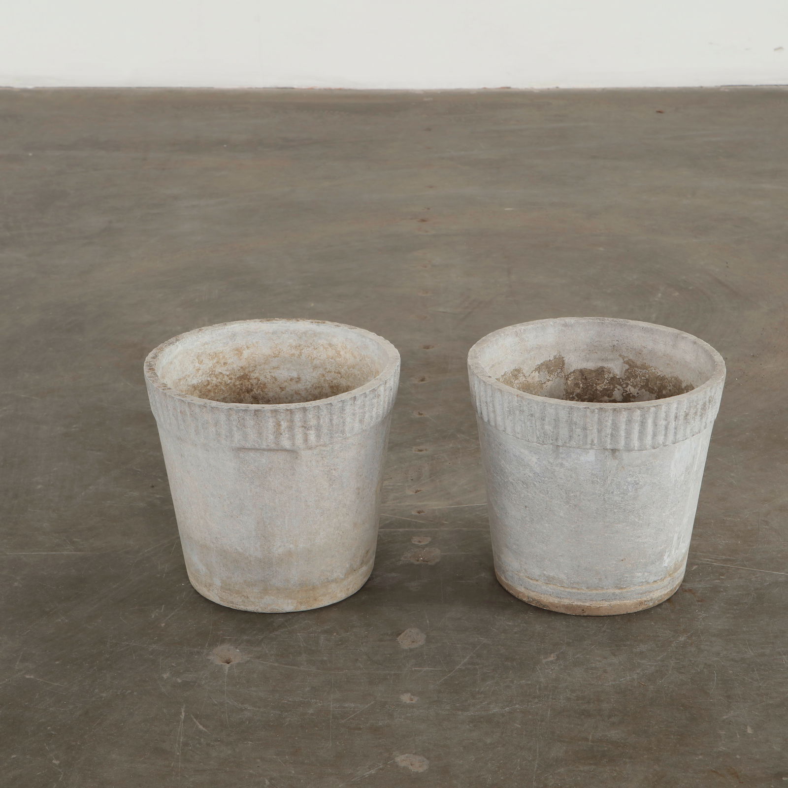 Willy Guhl, Pair of Small Round Planters, 1960s: Crafted in fiber cement with the quiet patina of decades outdoors, this pair displays Guhl understated Swiss modernism. The fluted rim and tapered form highlight the sculptural simplicity of the