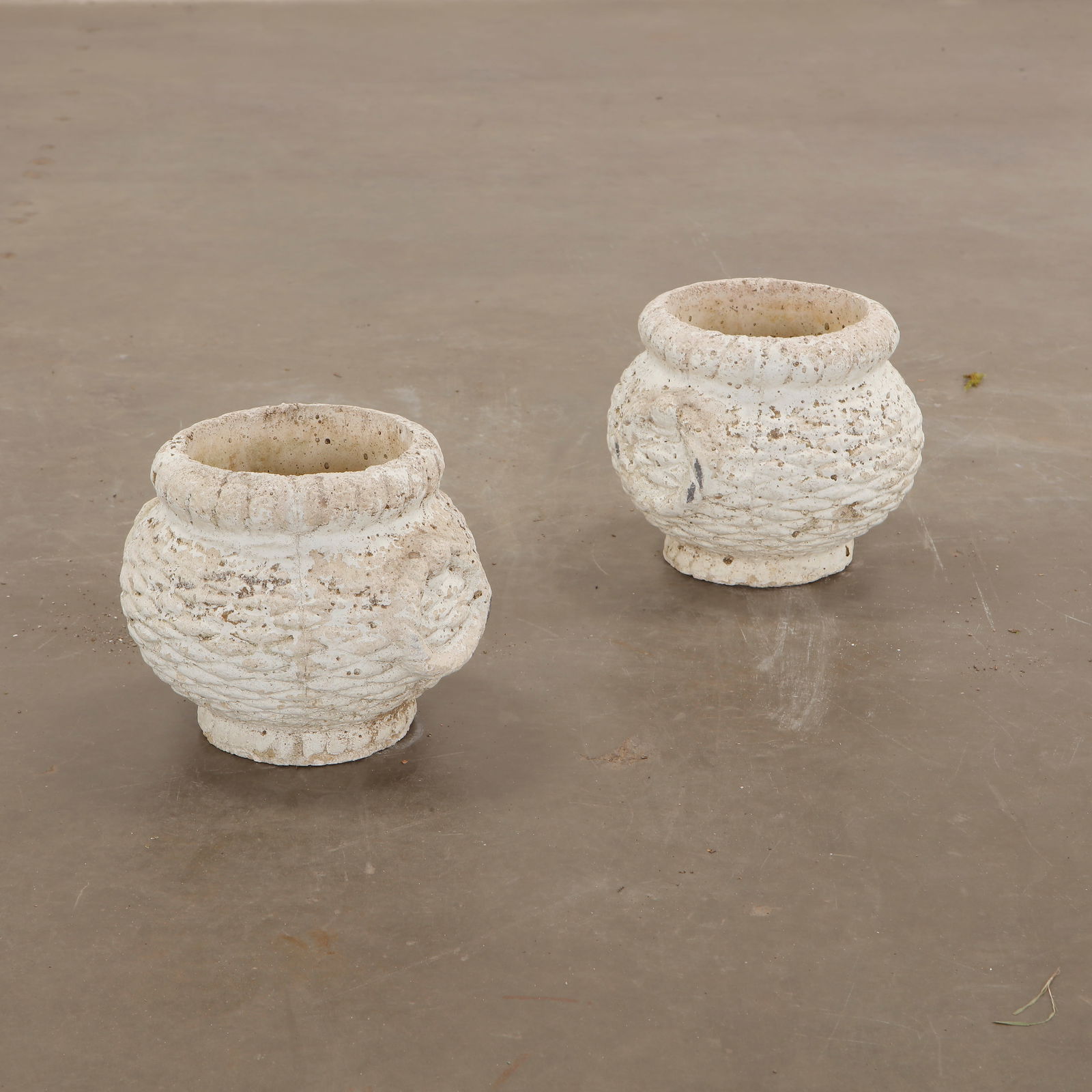 Pair of Small Round White Planters attributed to Grandon Fres, 1960s: A charming pair of small round white concrete planters with textured surfaces and aged patina. Ideal for adding vintage character to any garden. Overall Diameter: 9 in. Opening Diameter: 6 in.