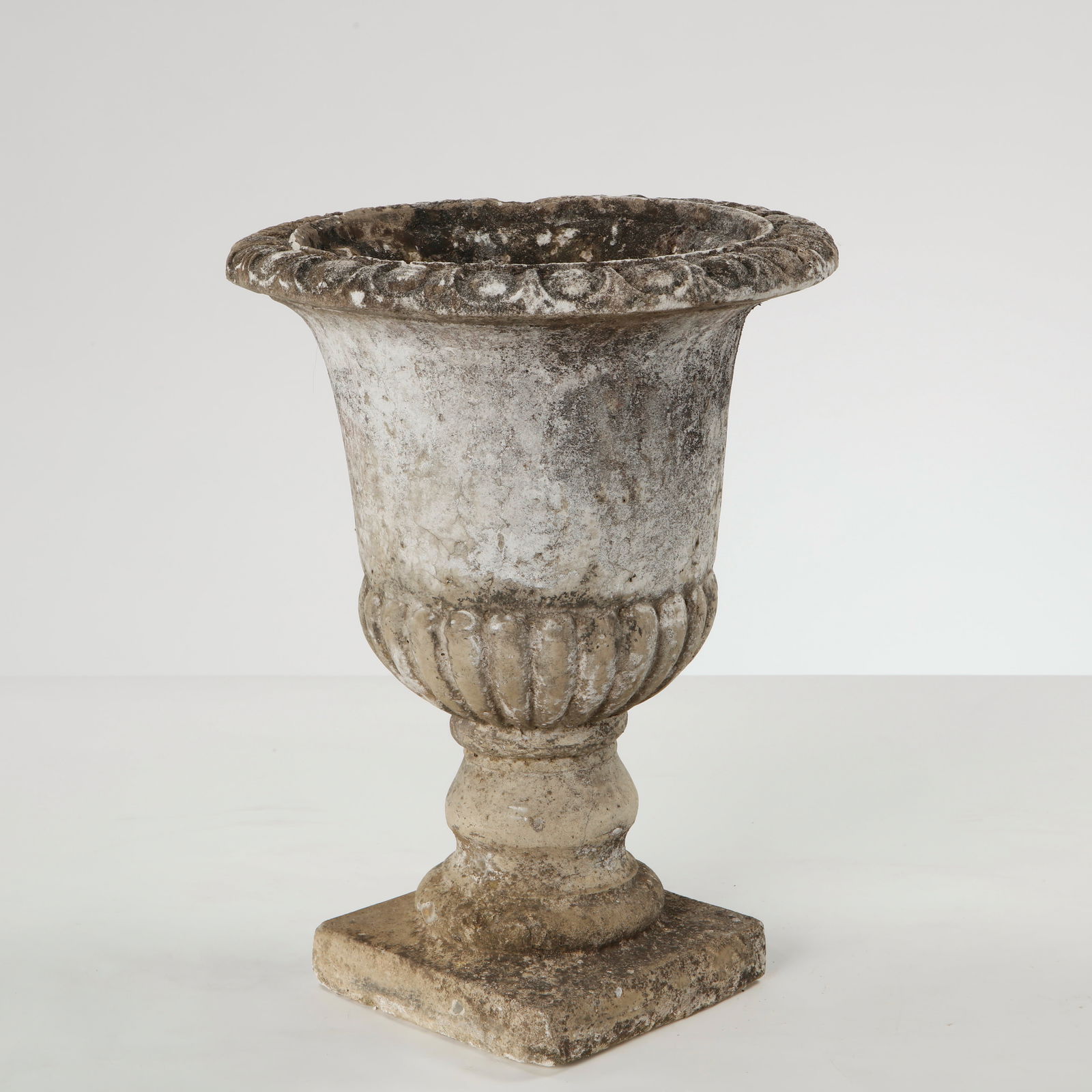 Small Cast Stone Urn Planter, 1960s: Small cast stone urn featuring a classical flared profile and molded rim. The surface displays a naturally aged patina, highlighting its sculptural form and garden provenance. Height: 15 in. Diameter: