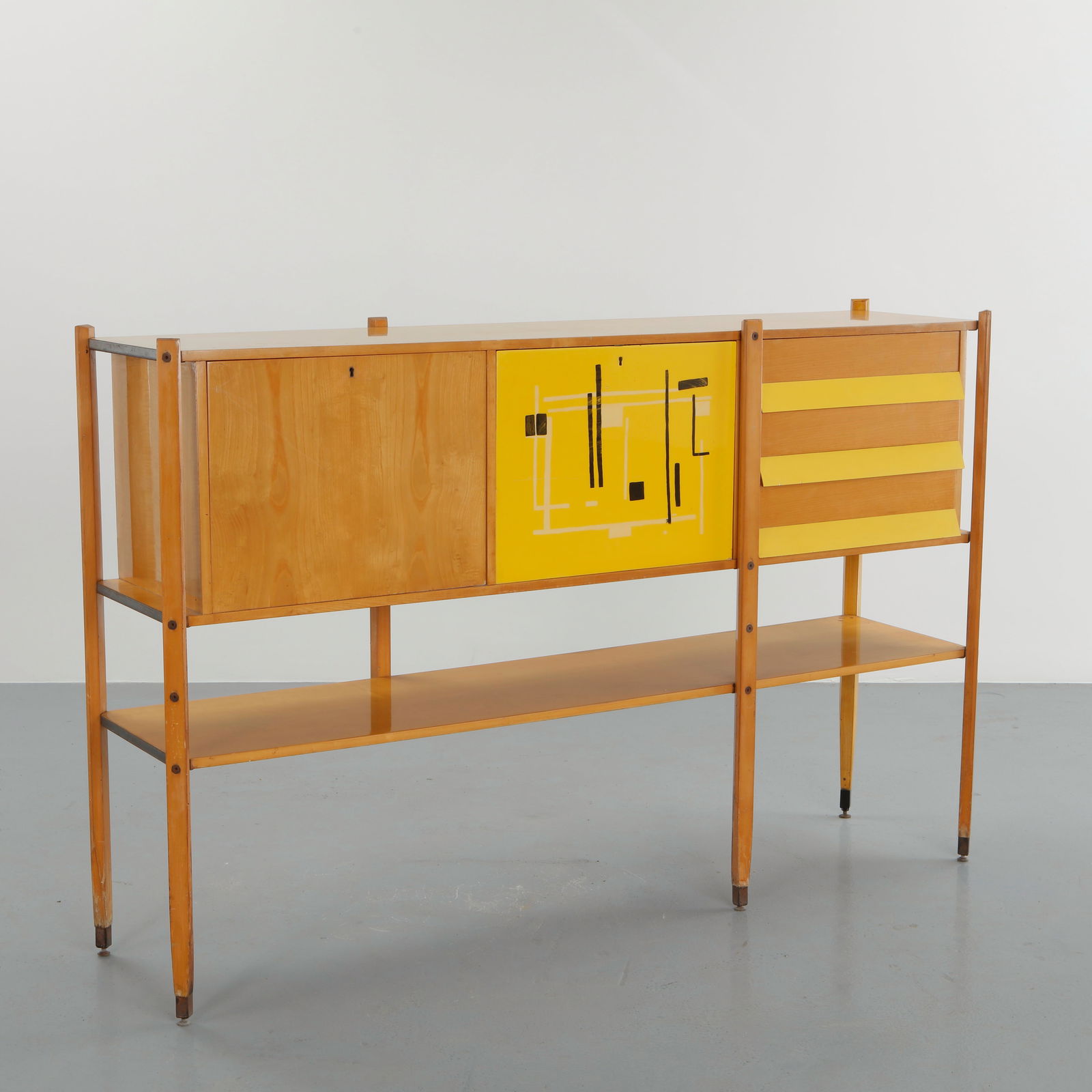 Roberto Aloi, Maple Sideboard, 1950s: Crafted in maple with a refined architectural frame, this sideboard features a striking yellow lacquered panel with abstract graphic composition. The open lower shelf and slender tapered legs emphasiz