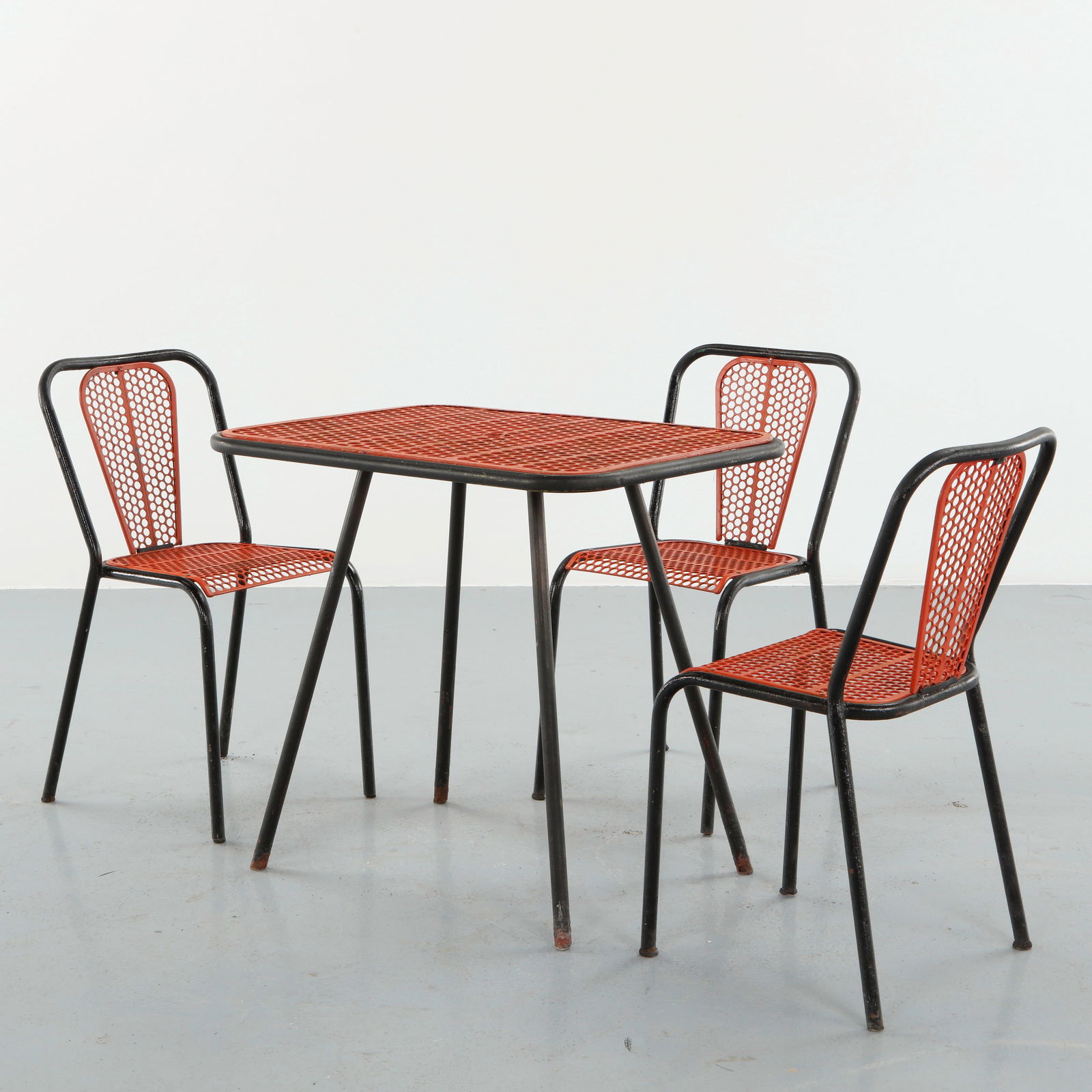 Rene Malaval, Red Outdoor Metal Dining Set, 1950s: Executed in painted perforated metal with black tubular frames, this dining set features a red geometric pattern that embodies postwar optimism and graphic modernity. Designed for outdoor use, it comb