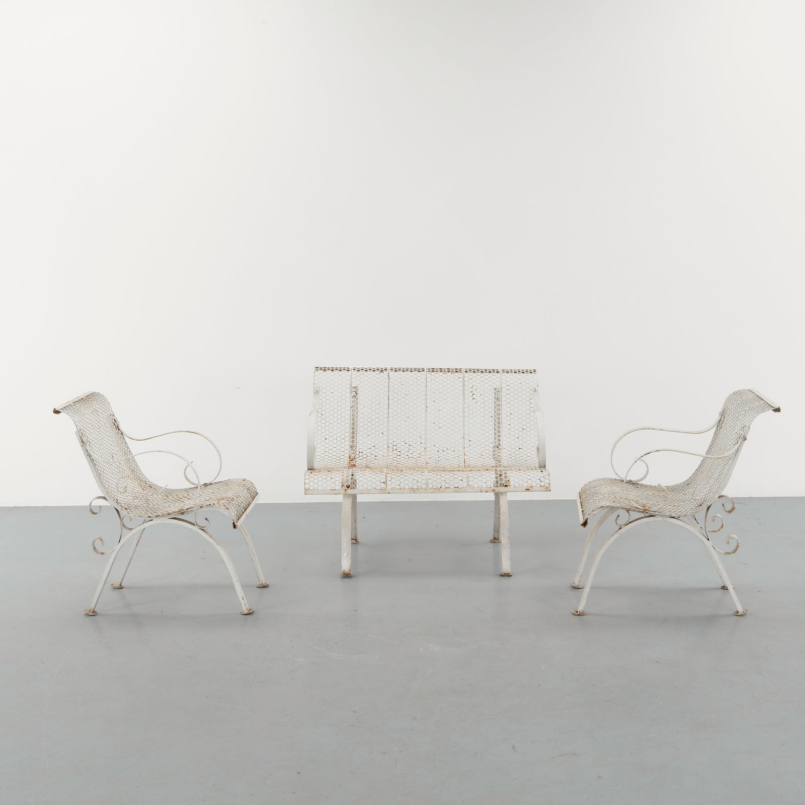 Rene Malaval, Outdoor Metal Living Room, 1950s: An elegant outdoor ensemble executed in perforated and curved metal, featuring two lounge chairs and a matching settee with sinuous armrests and sculptural profiles. The honeycomb surface creates a re