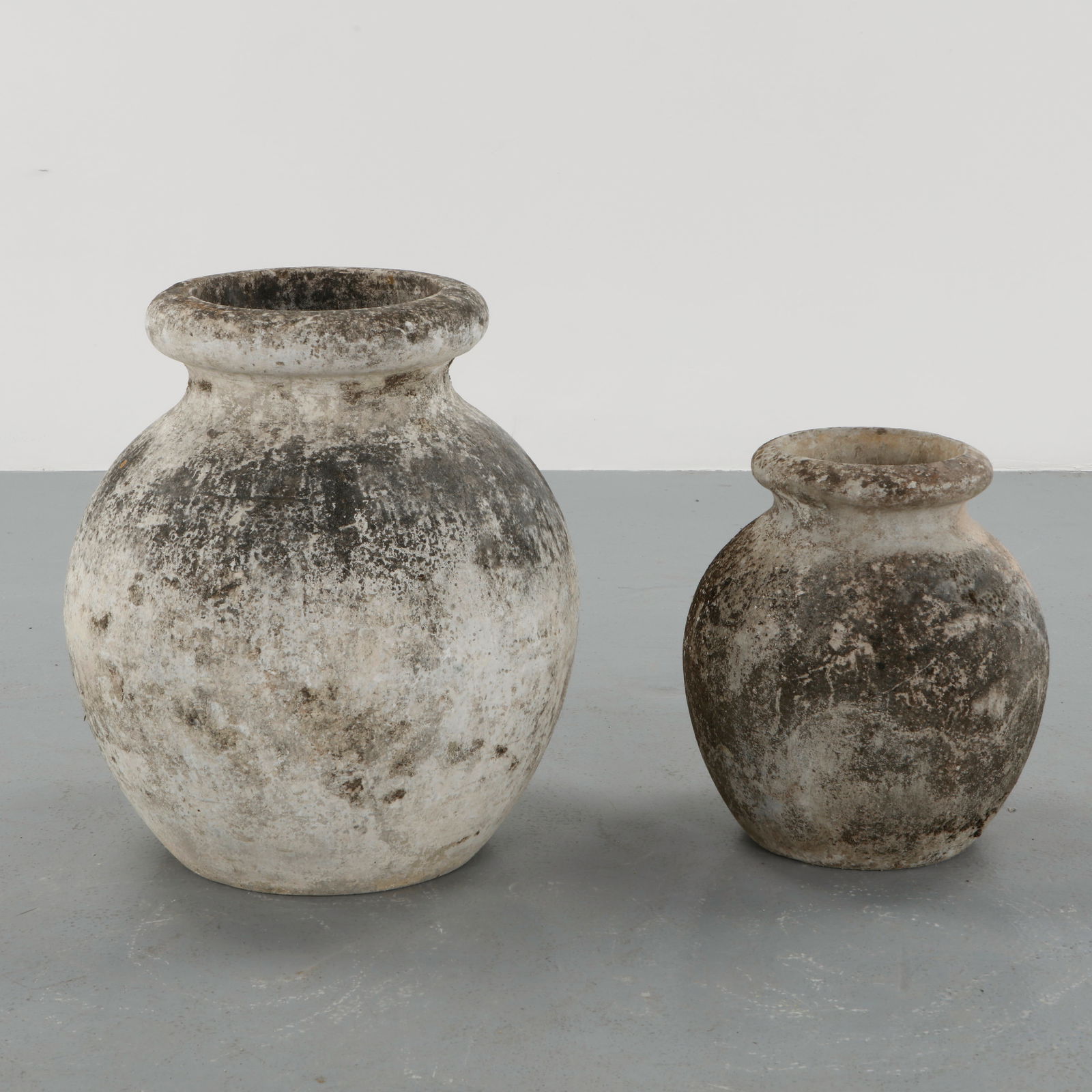 Willy Guhl, Pair of Medium and Large Jar Planter, 1960s: Crafted in cast concrete with a generous rounded body and wide collar rim, this vessel bears a richly weathered surface with lichen and patina from decades of outdoor use. Small: Height: 21 in.