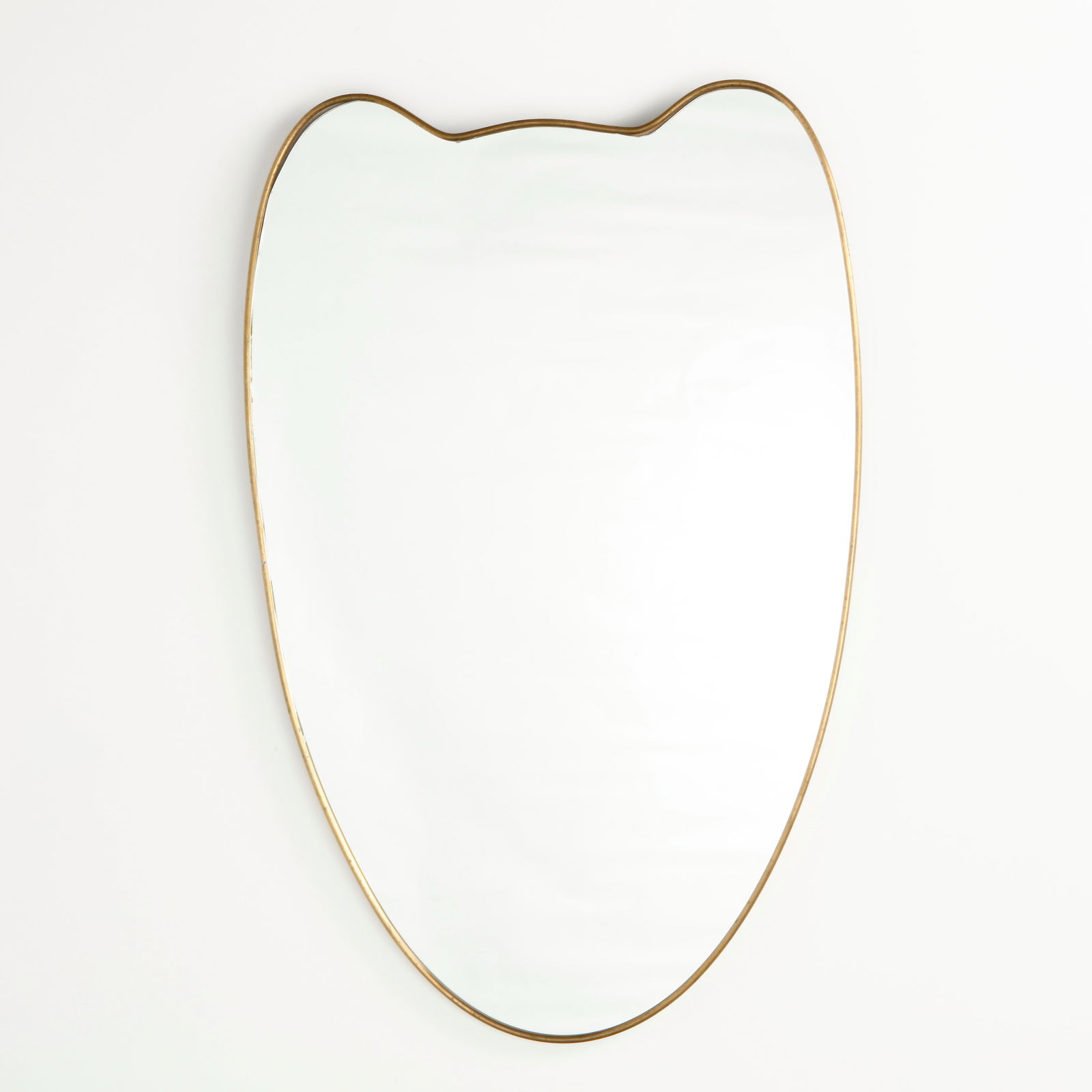 Italian Brass Double Crest Mirror, 1960s: Striking mirror defined by a distinctive double crest contour and a continuous brass frame. The rhythmic curves and elongated lower line create a graceful, shield like silhouette typical of Italian mo