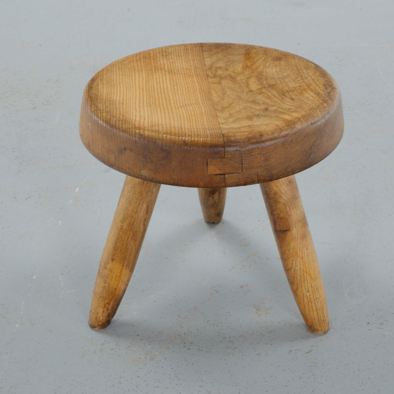 Wood Stool attributed to Charlotte Perrriand, 1960s: Carved from solid wood, this low stool presents a simple, utilitarian form emphasizing natural grain and craftsmanship. A restrained yet expressive example of Perriand humanist design philosophy. Heig