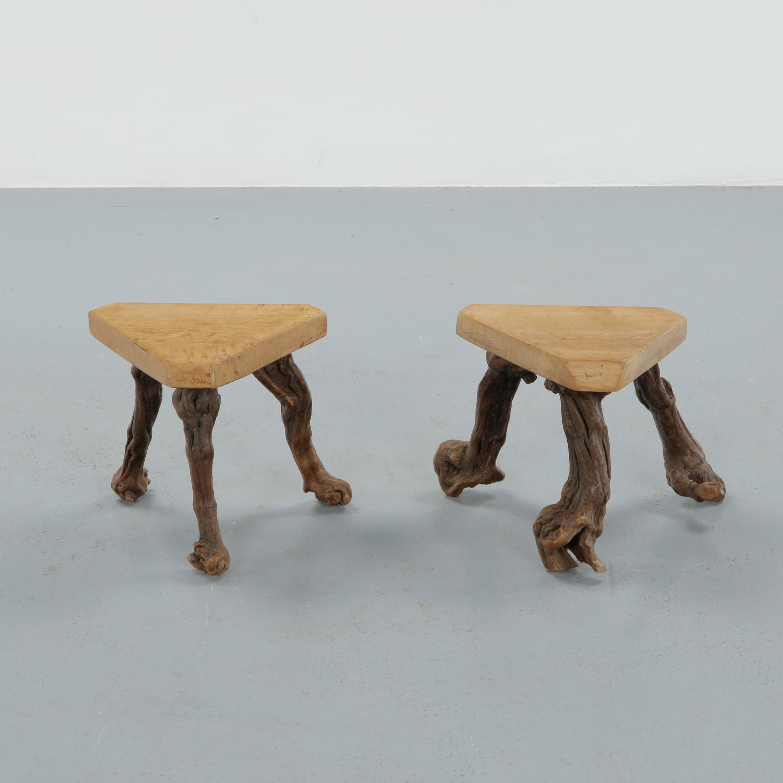 Pair of Brutalist Triangular Wood Stools, 1960s: Featuring thick triangular seats supported by expressive root-like legs, this pair of stools celebrates raw materiality and hand-crafted construction. Strongly rooted in brutalist design language. Hei