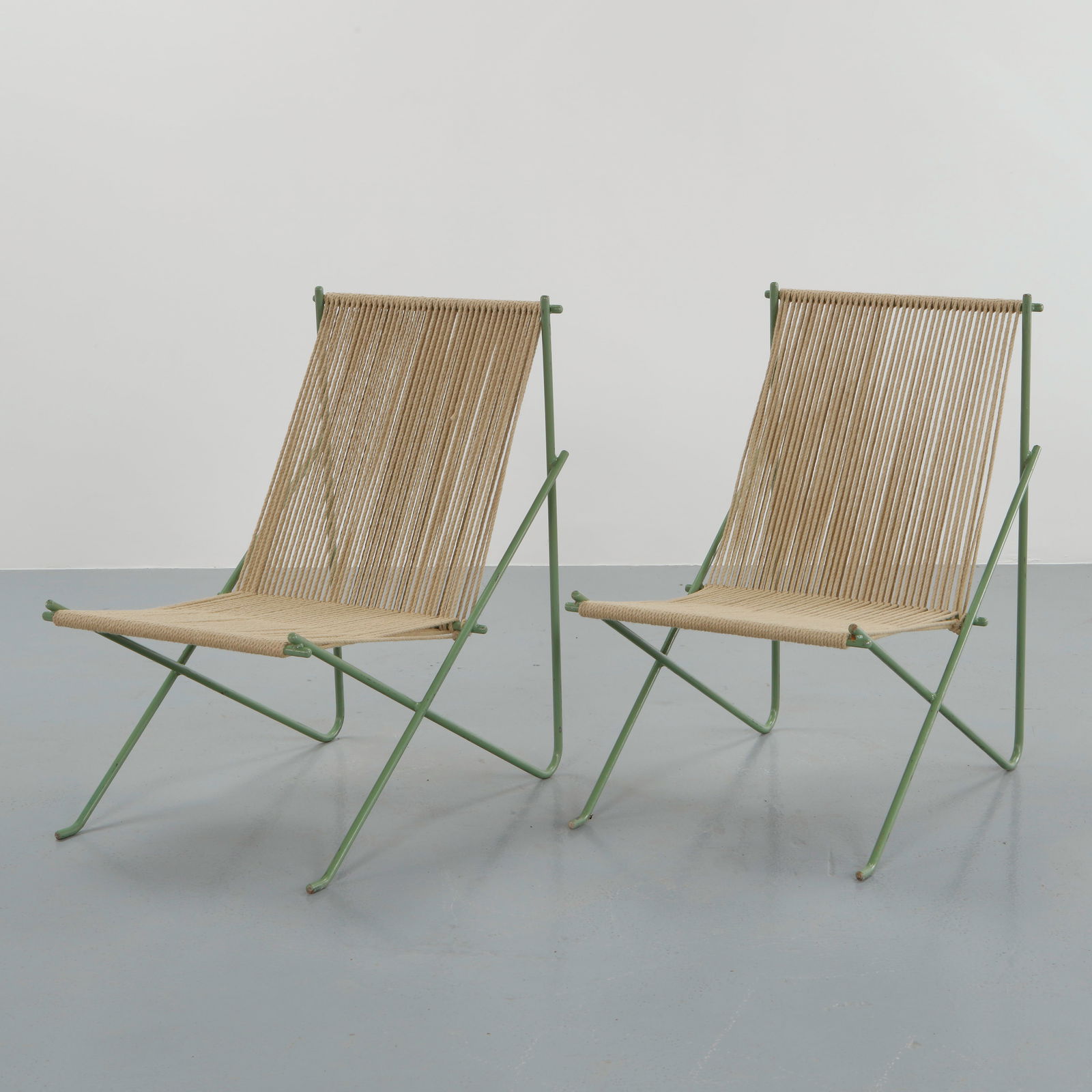 Allan Gould, Pair of Rope Chairs, USA, 1950s: A refined pair of lounge chairs featuring green tubular steel frames and handwoven rope seating. Exemplifying Gould commitment to functional beauty, these chairs balance sculptural form with tactile