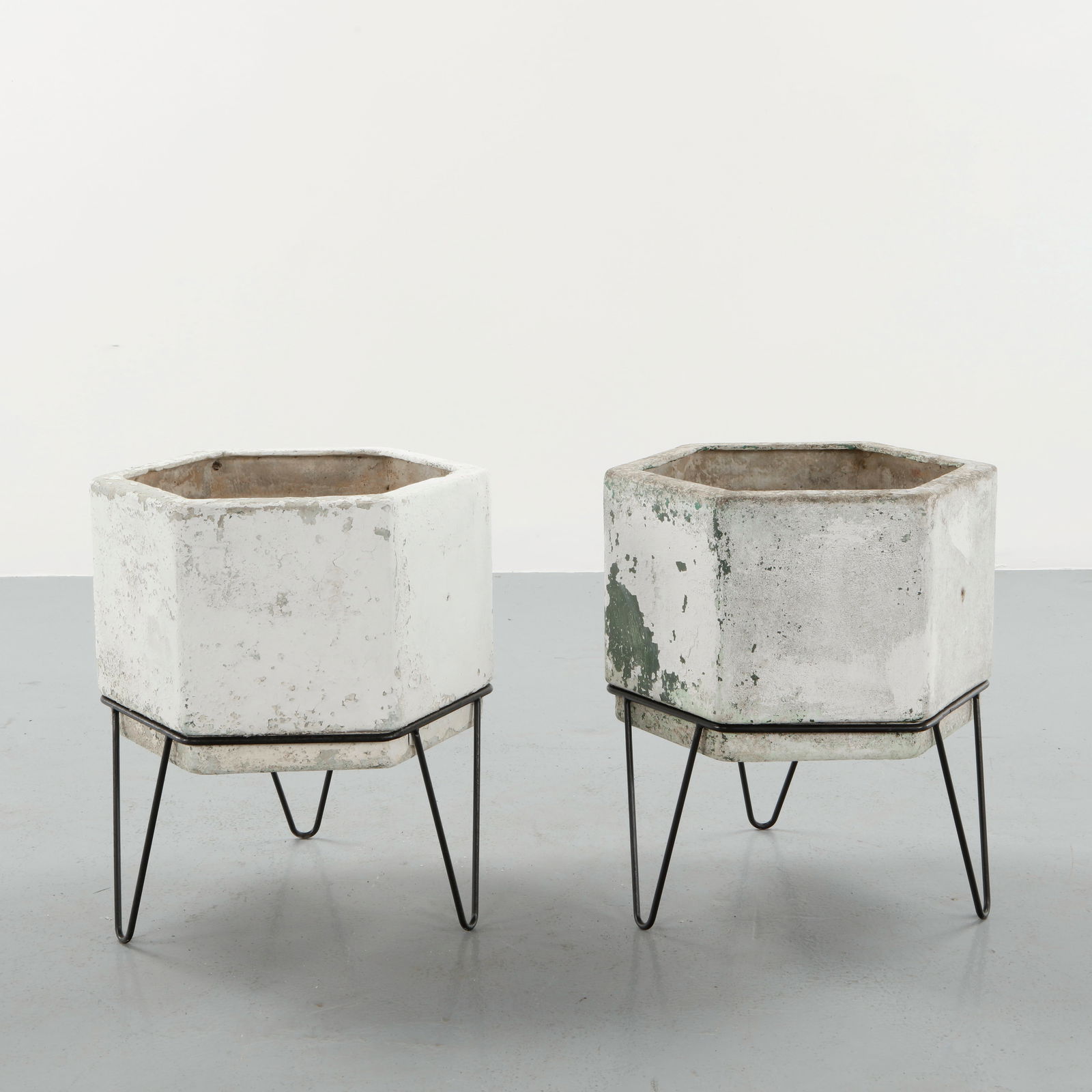 Willy Guhl, Pair of Hexagona Concrete Planters on Stands, 1960s: Pair of hexagonal molded concrete planters raised on metal stands. Displaying expressive aging with traces of lichen and mineral deposits. Highly sought-after examples of Swiss modernist outdoor desig