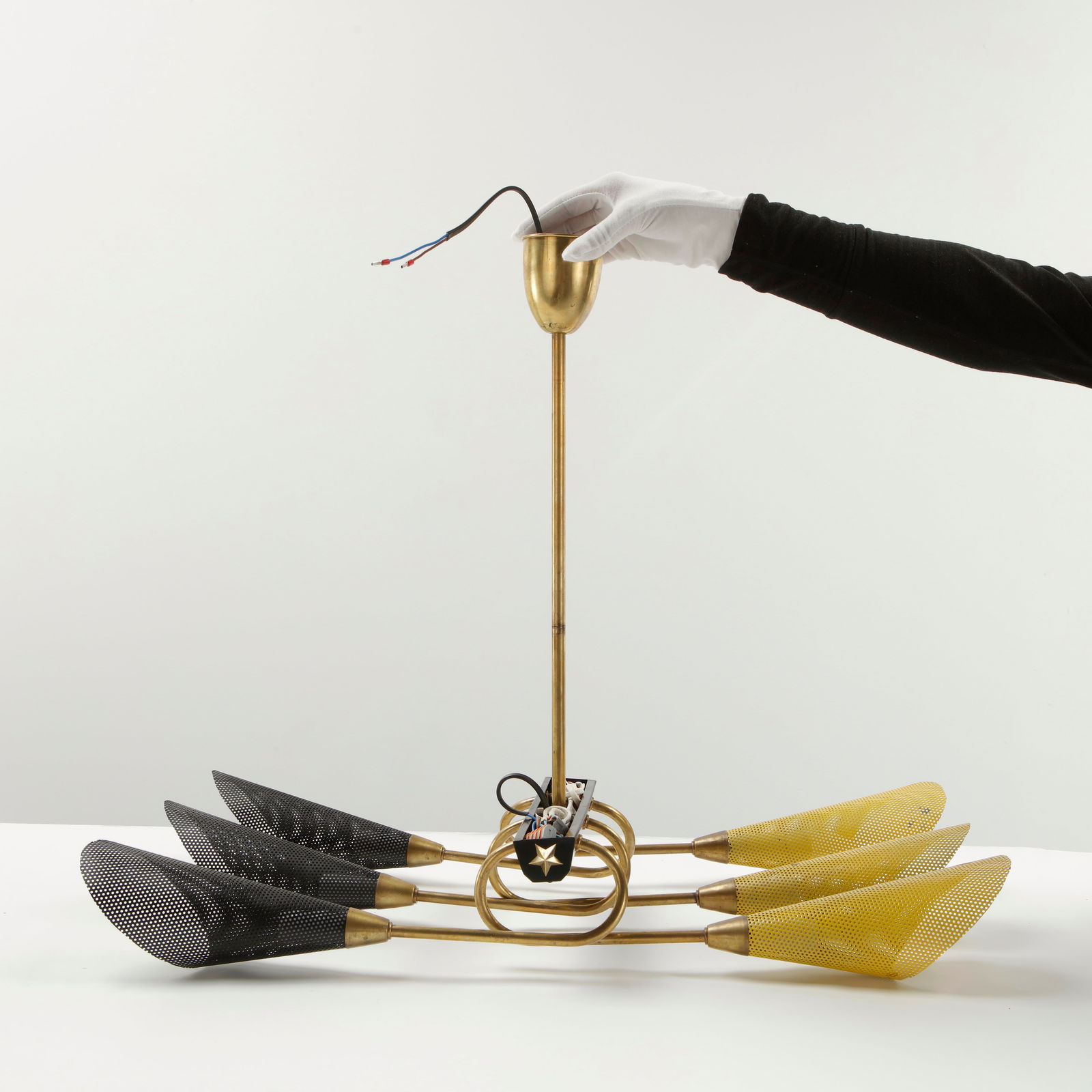 Perforated Metal Ceiling Lamp in the style of Mathieu Mategot, 1950s: A dynamic ceiling light featuring multiple perforated metal shades in contrasting colors, mounted on articulated brass arms. Inspired by the playful industrial vocabulary associated with Mathieu