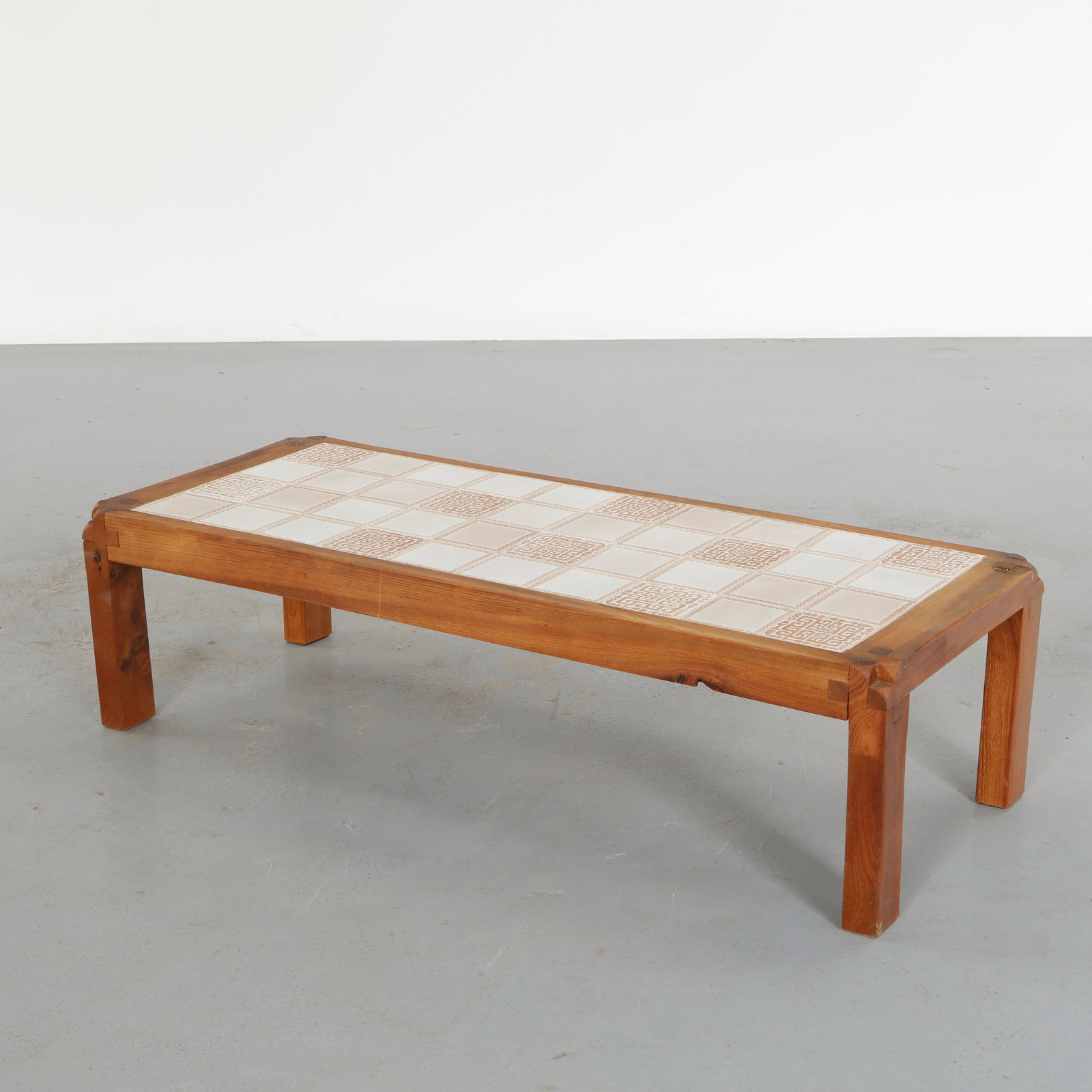 Pierre Chapo, Ceramic Coffee Table, 1960s: Crafted in solid wood with expressive structural joinery, the robust base supports a ceramic tiled top combining warmth of timber and mineral texture. The composition reflects the honest materiality