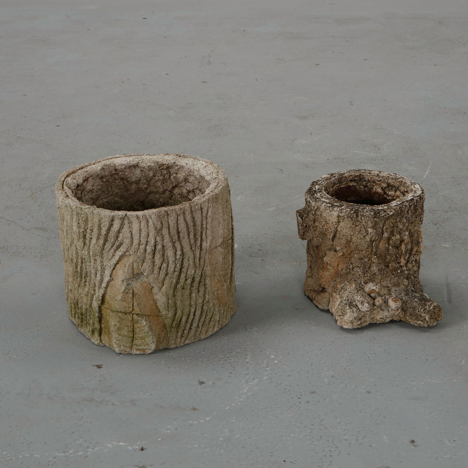 Pair of Faux Bois Planters, 1960s: Pair of rustic planters executed in cast concrete with surfaces carved to evoke the texture of tree bark. The organic relief and irregular contours celebrate the traditional faux bois garden craft.