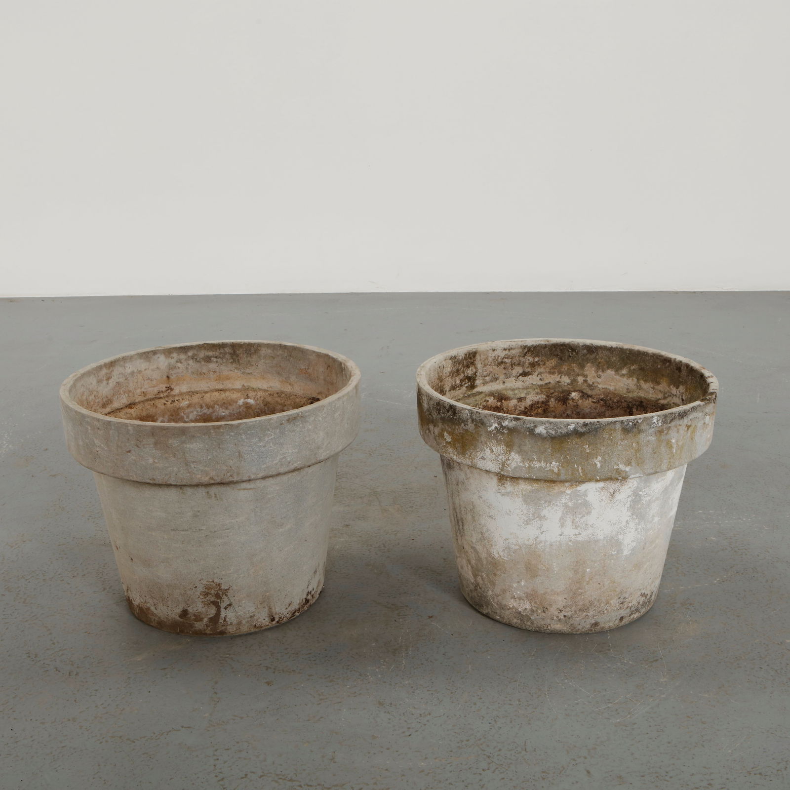 Willy Guhl, Pair of Round Planters, 1960s: Executed in fiber cement with softly curved silhouettes. These planters exemplify Guhl approach to functional sculptural outdoor design. Naturally aged surfaces enhance their sculptural quality.