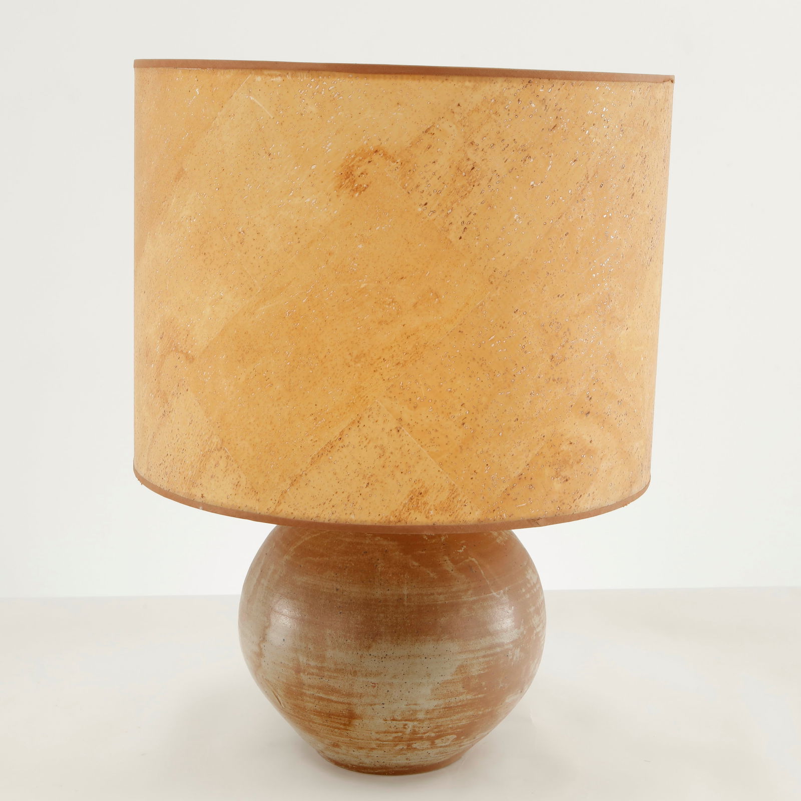 Ceramic Table Lamp with Spherical Base, 1970s: Table lamp featuring a hand thrown ceramic base of rounded spherical form finished in warm earthy tones with subtle horizontal glaze variations. The piece is paired with a textured cylindrical shade w