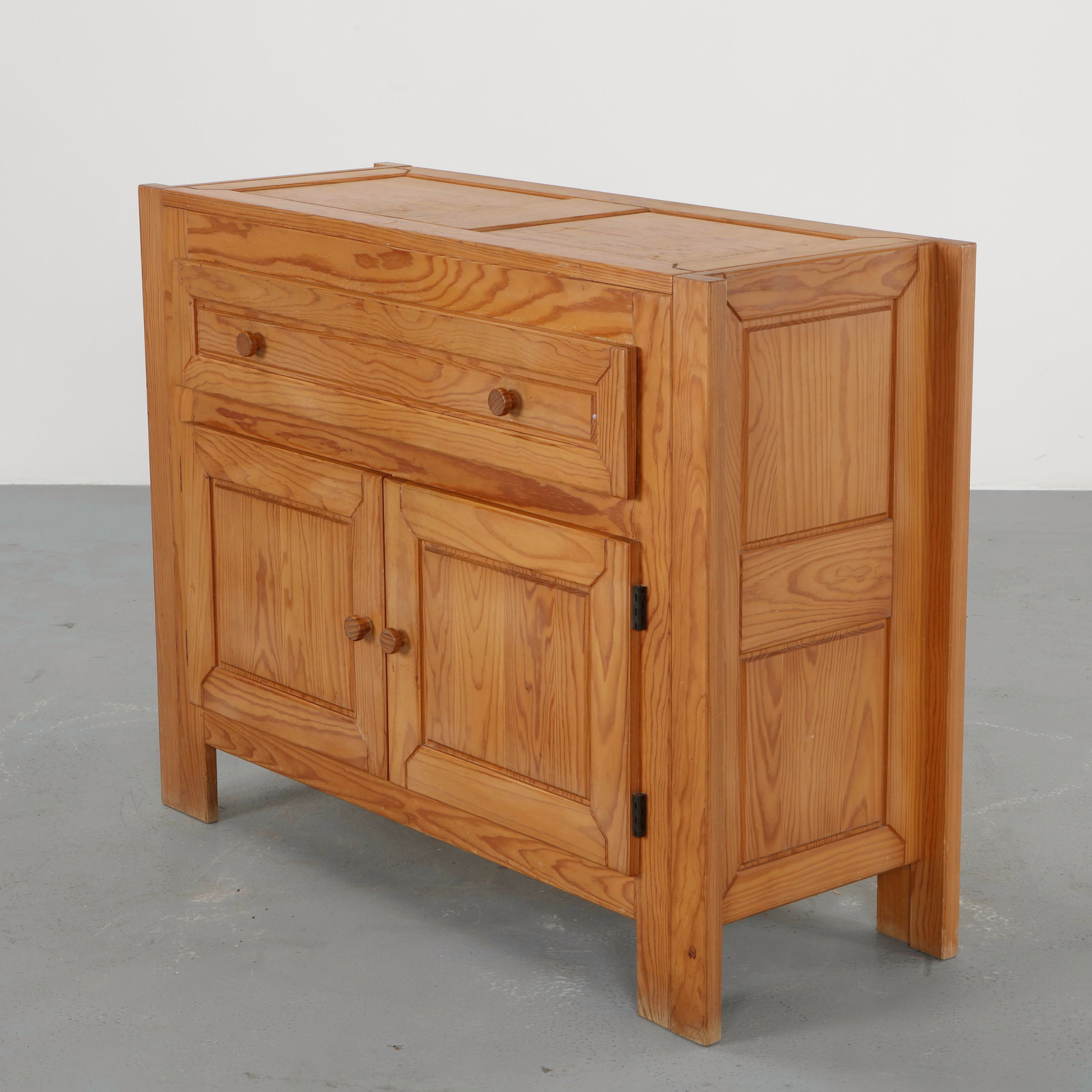 Wood Sideboard in the style of Charlotte Perriand, 1960s: Sideboard crafted from solid pine featuring a drawer above two cabinet doors with simple wooden pulls. The warm tone of the wood and restrained construction recall the utilitarian elegance of alpine